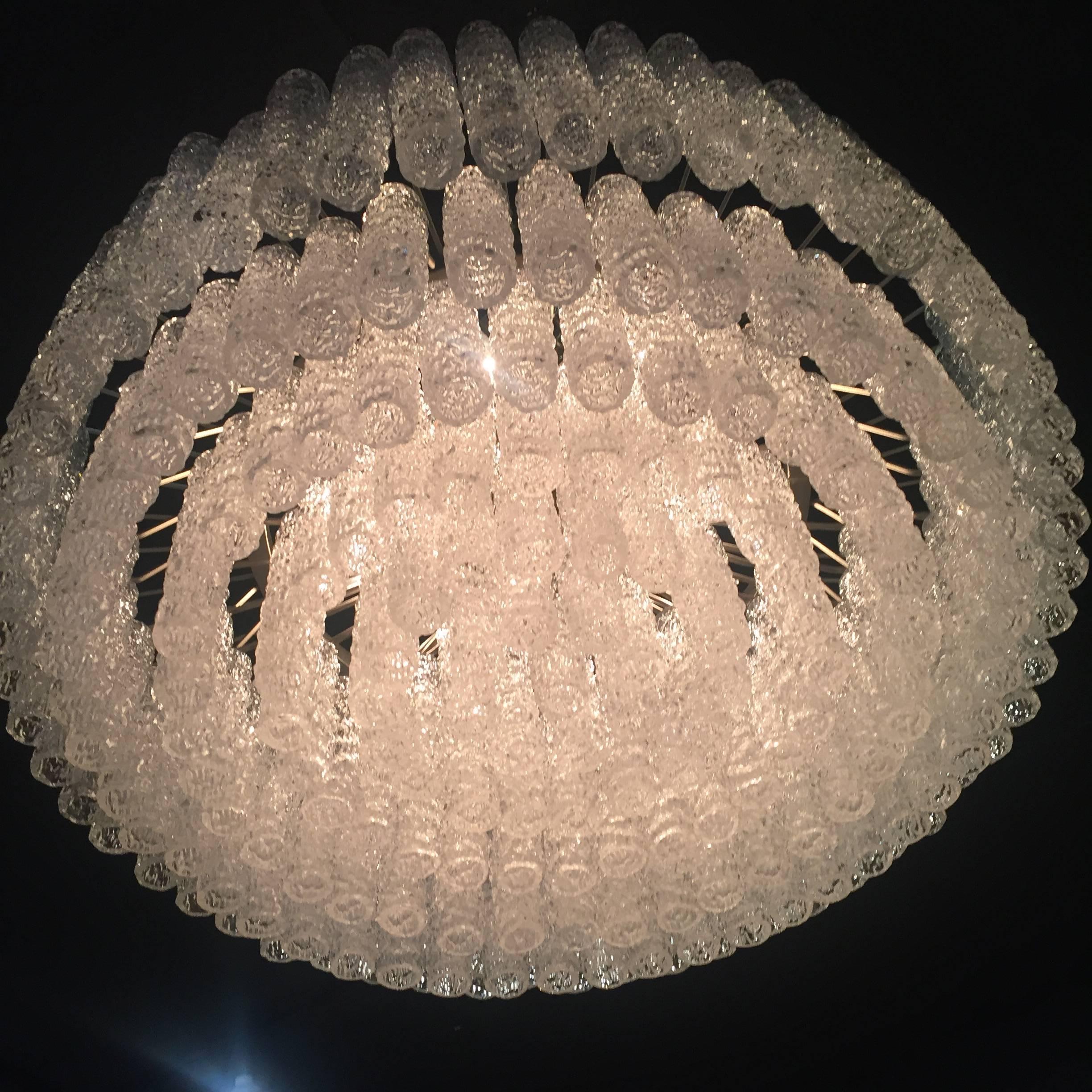Very impressive Murano glass chandelier, thickly layered textured glass trench tubes make a strong impression from beneath. The fixture takes 12 standard torpedo bulbs. Wiring has been professionally checked and updated. 
  