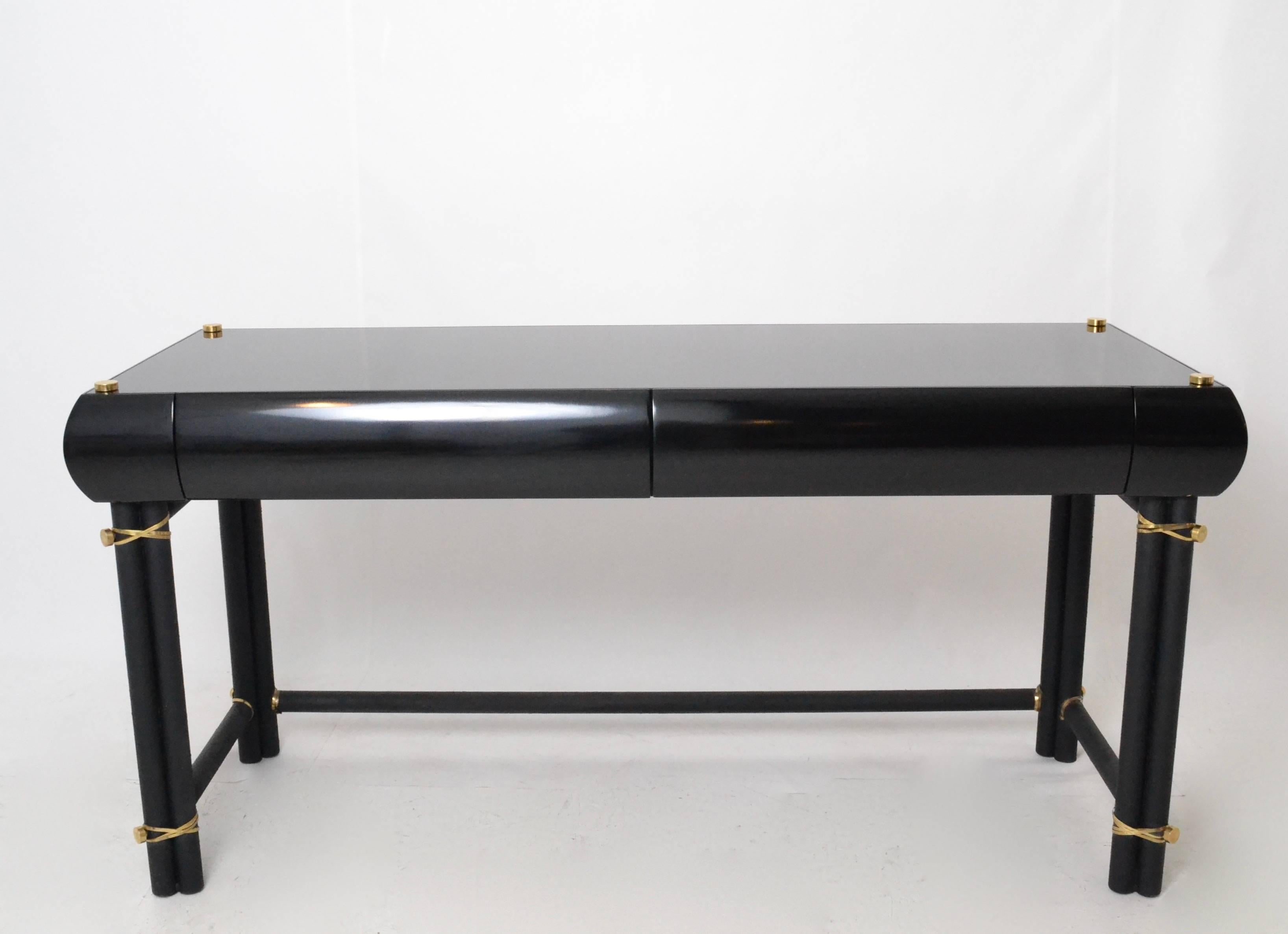 Quality desk with metal legs powder coated in textured black and a gloss lacquered wood top. Nice solid brass details on top and legs. Two drawers.