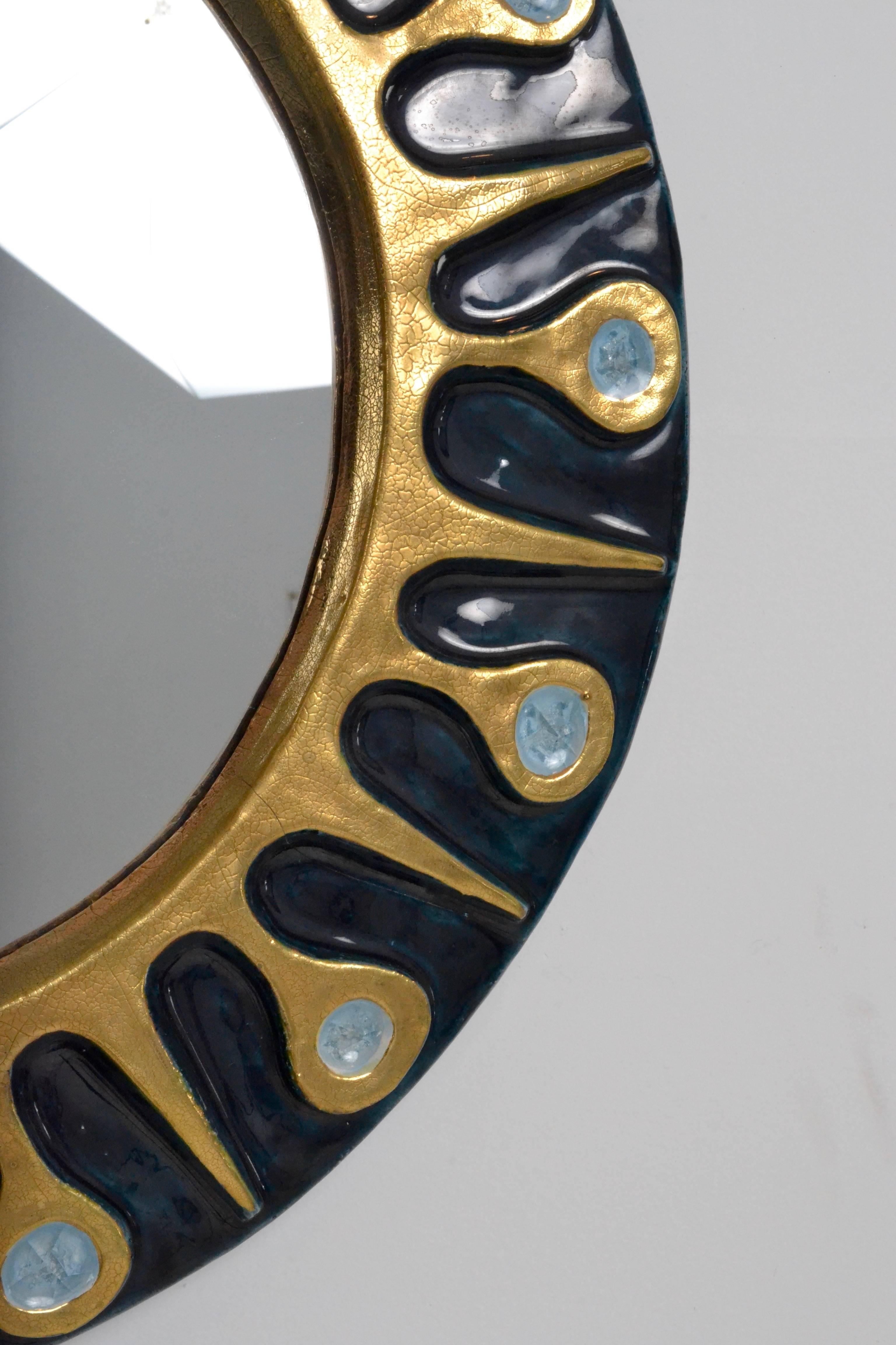 Decorative mirror with distinctive design featuring a dark teal glaze combined with metallic gold and crackled glass inserts.