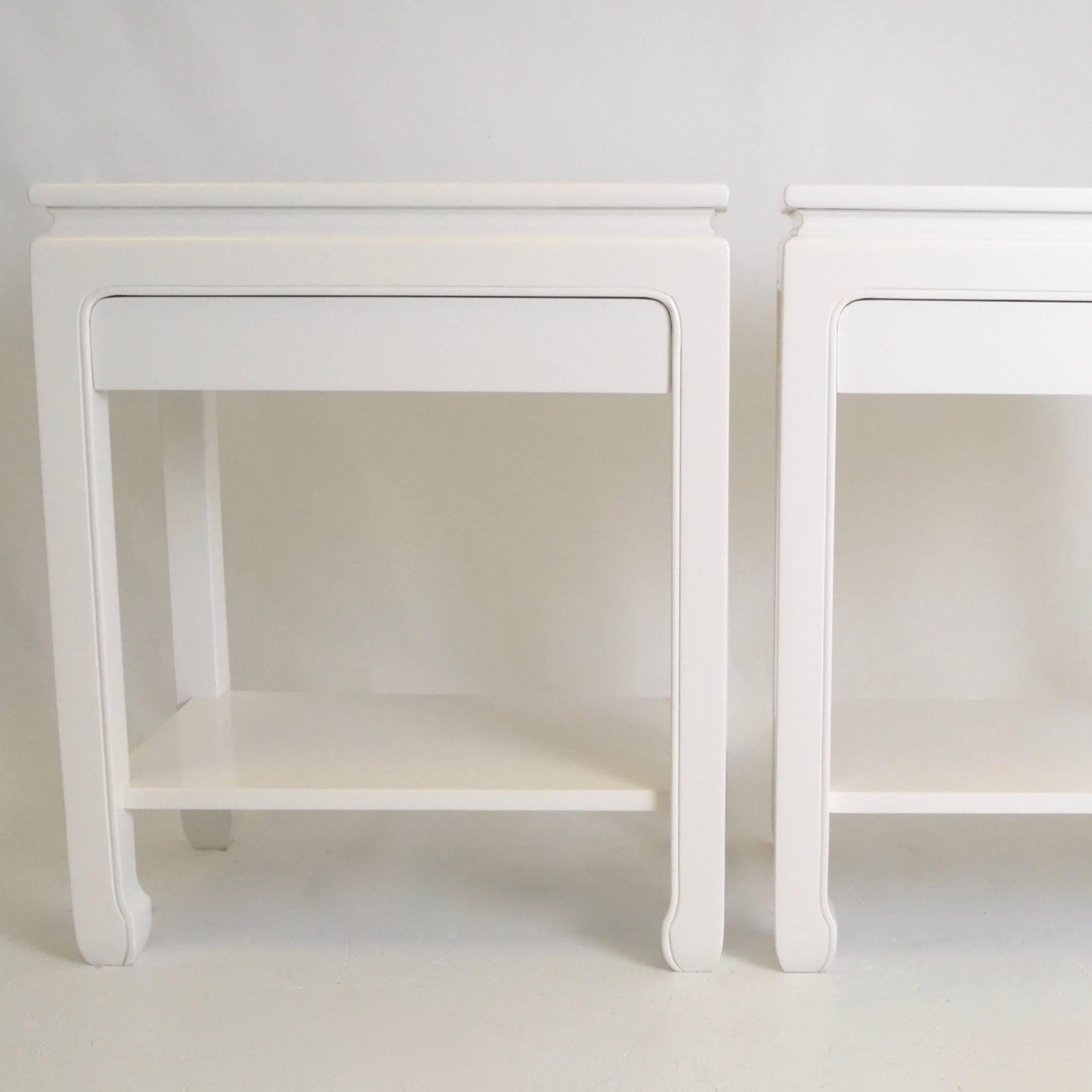 A very handsome pair of end tables or nightstands, each with a single drawer and lower shelf. Oriental styling. Newly lacquered in sating dove white.
