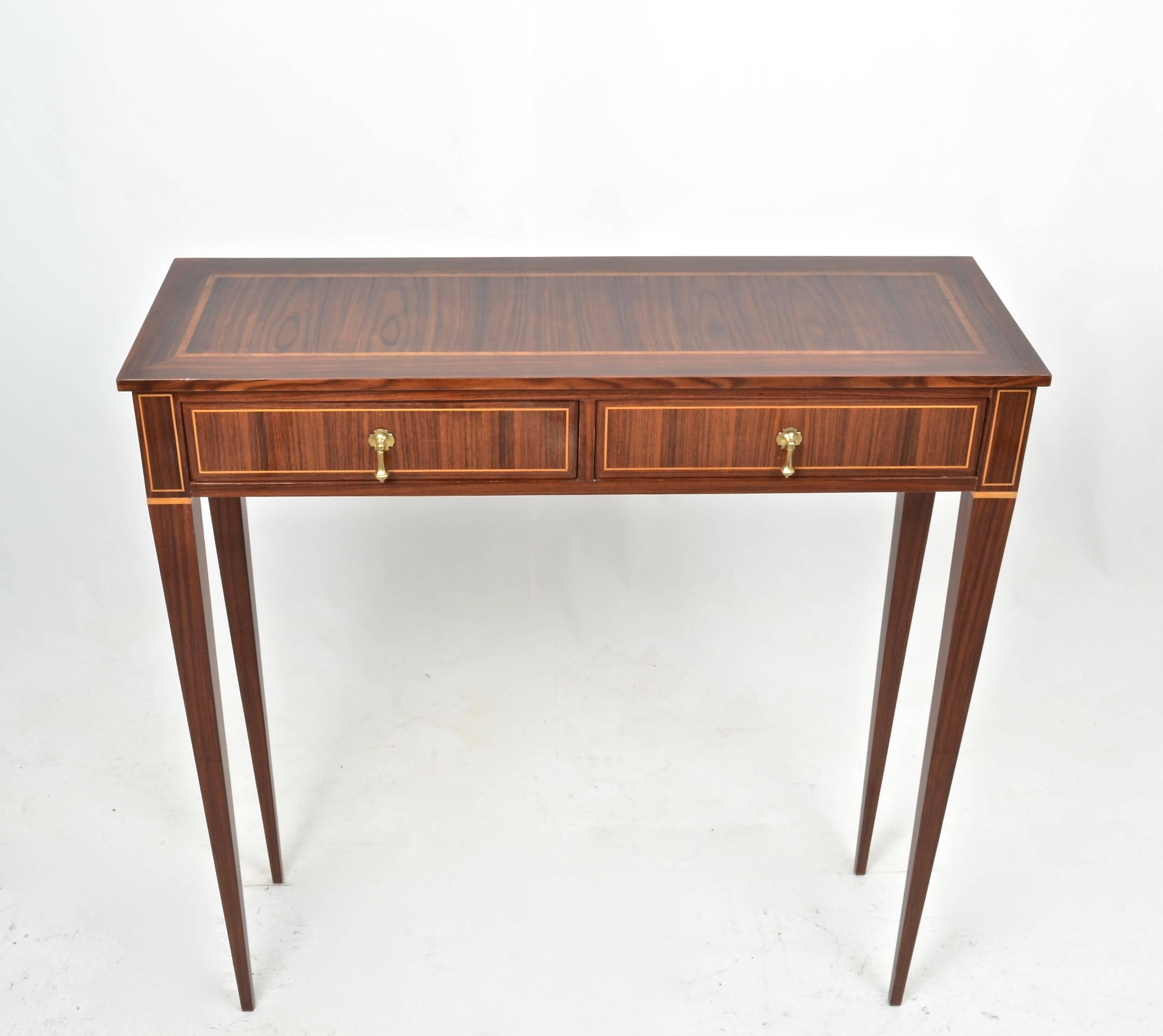 Beautifully formed petite console table featuring exotic woods and simple inlays. Fine tapered legs; two drawers. Quality construction. In the style of Famed Italian designer Paolo Buffa.