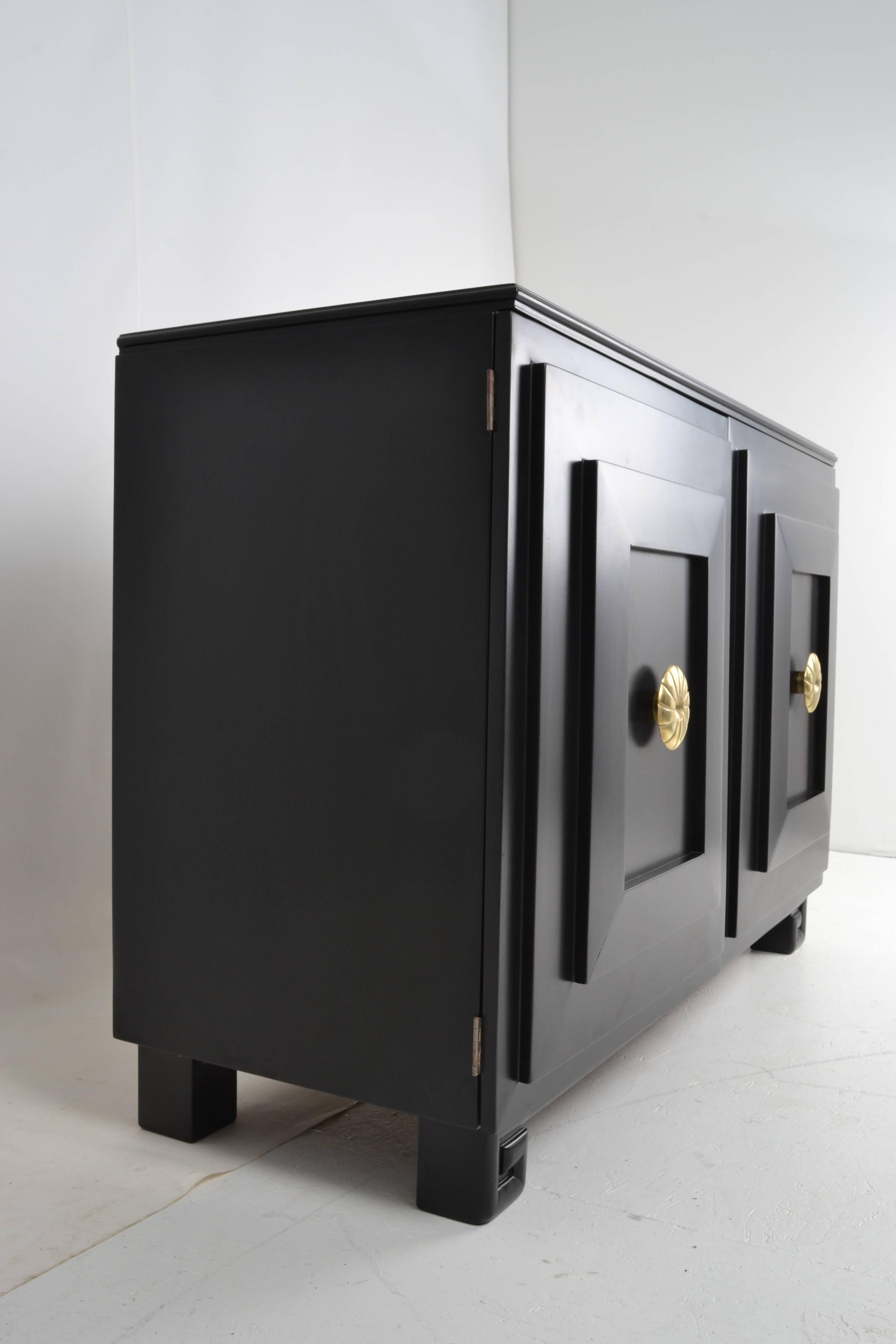 A handsome cabinet fully restored in satin black lacquer. Large decorative brass pulls. Nice Greek key detail on feet. Right side has fitted drawers, left has adjustable shelf. Quality construction. 