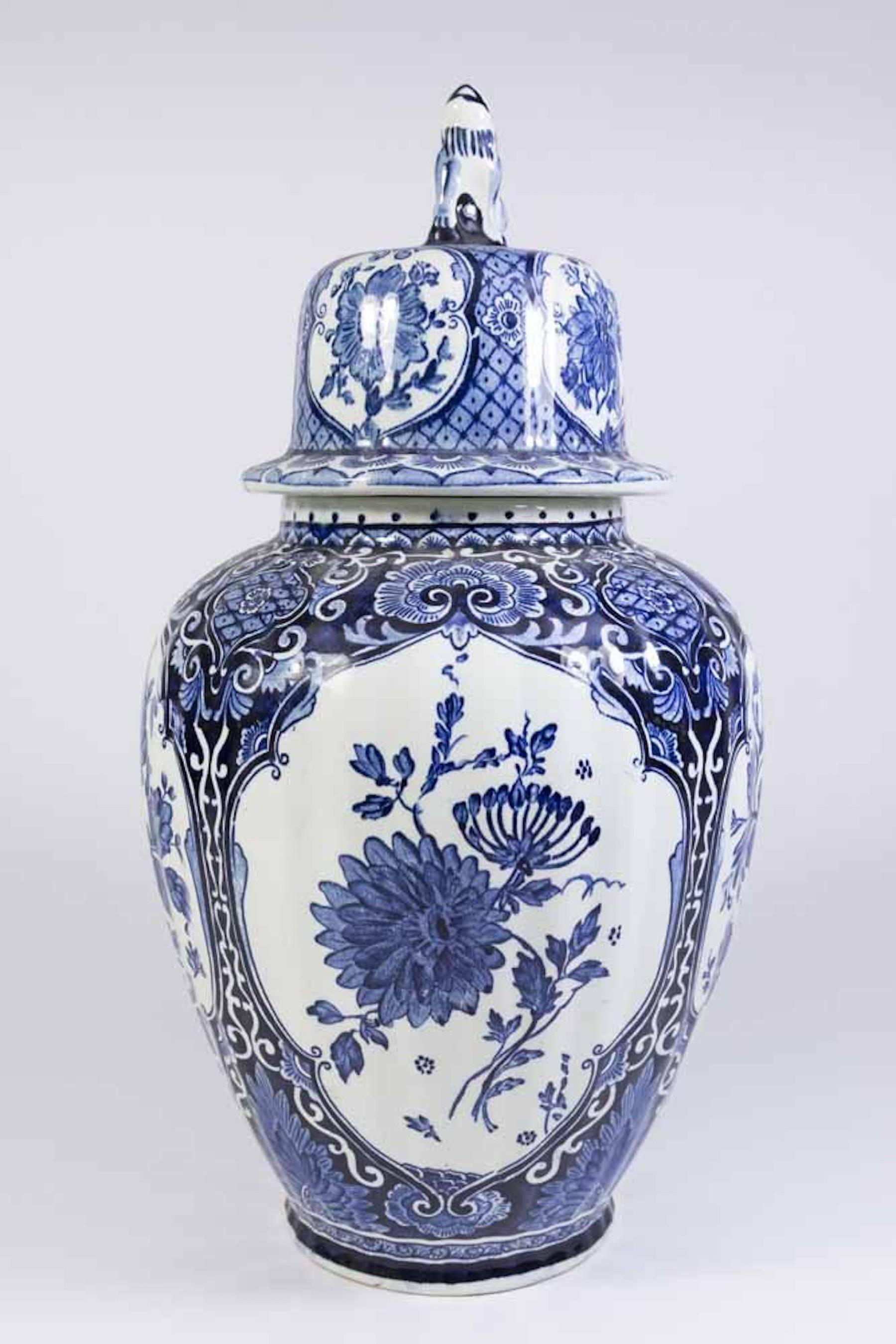 Pair of Delft style ginger jars, each one of typical form and decoration with foo dog finials.