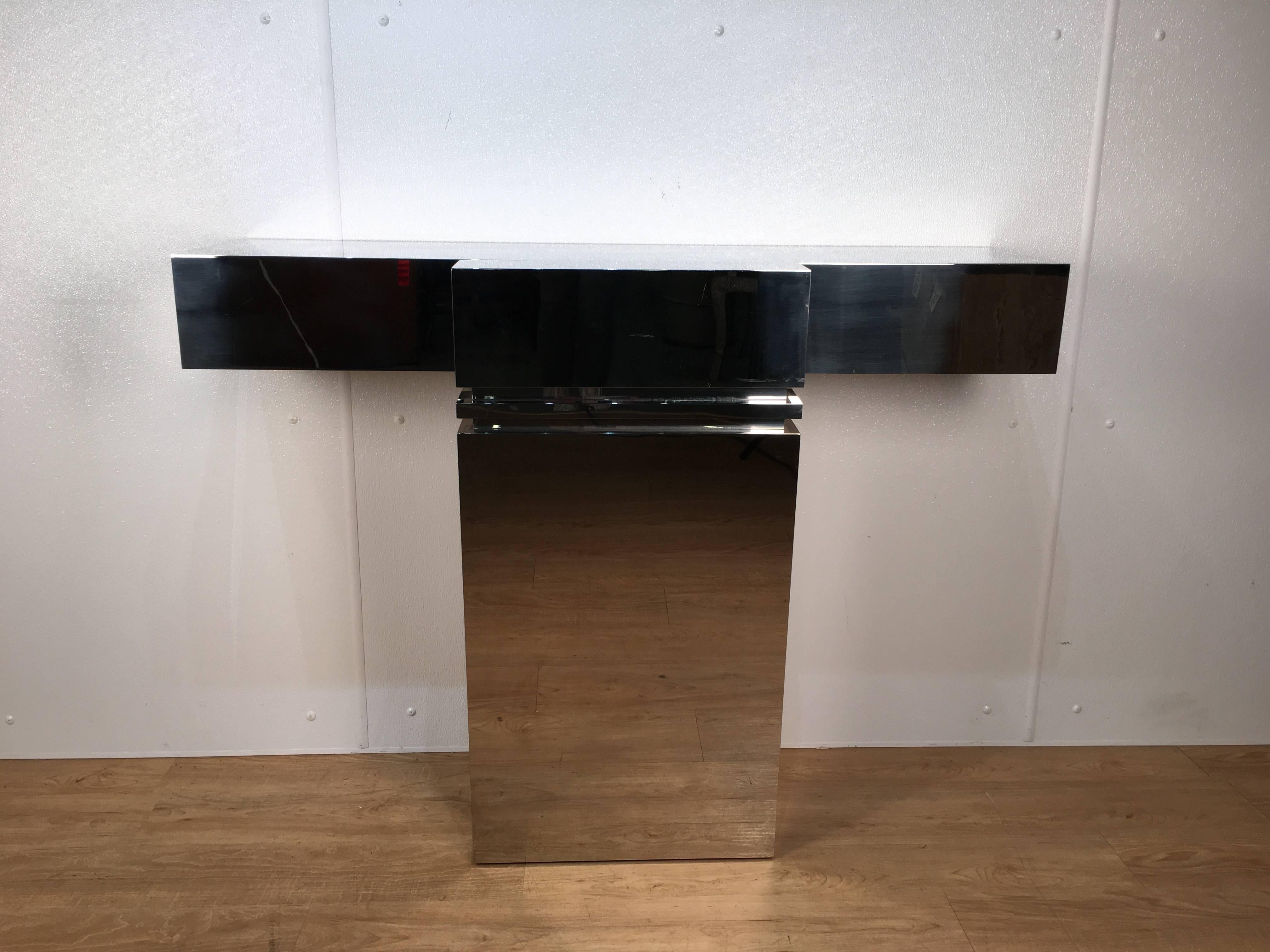 Breuton style chrome console raised on a monolith pedestal with recessed top. Option for illumination from underneath console top. Chrome shows normal wear consistent with age and use and presents very well. Console must be attached to the wall for