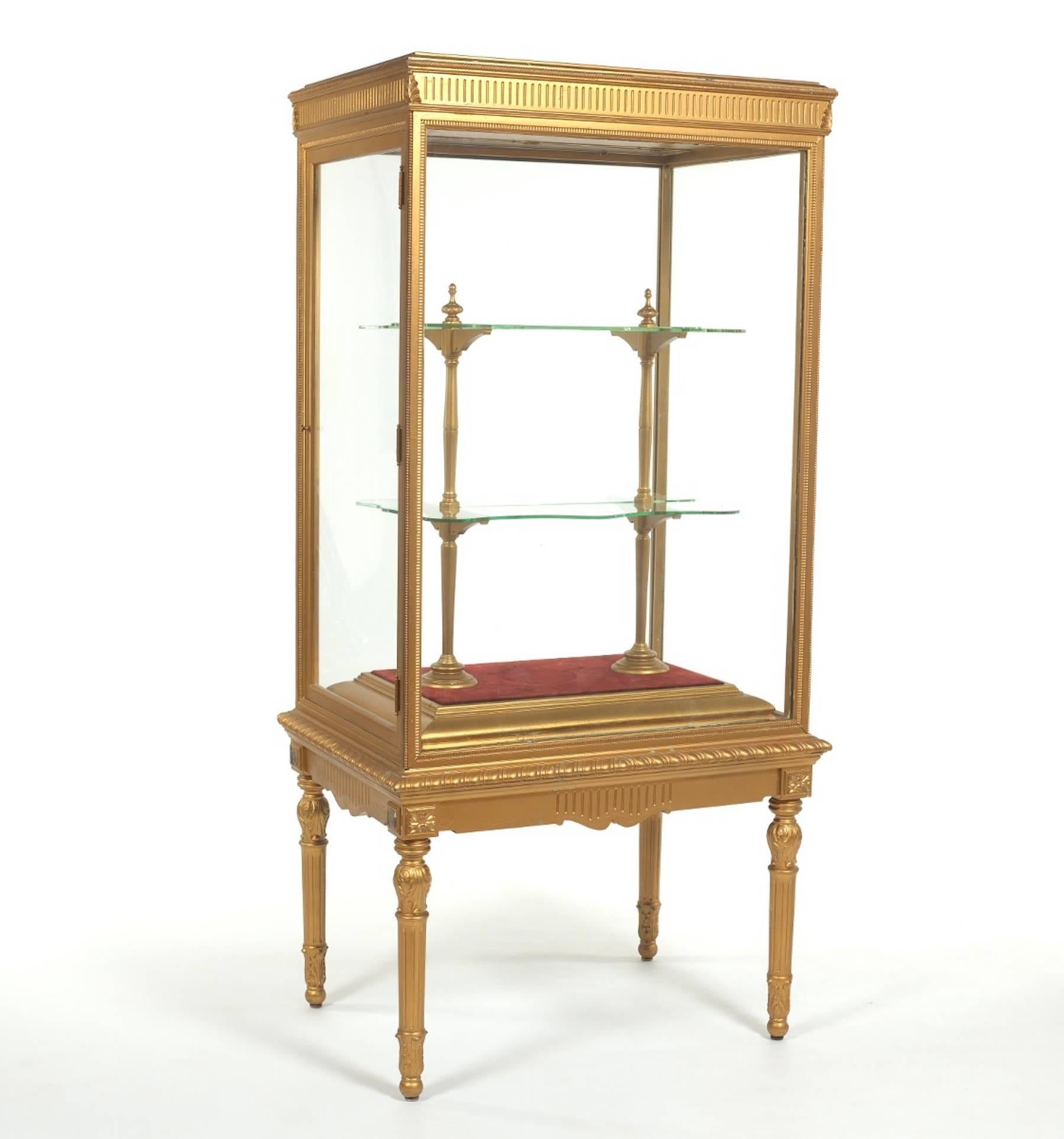 Pair of French neoclassical giltwood standing cabinets or vitrines, each one of excellent proportions, with four interior serpentine glass shelves, encased in a neoclassic carved giltwood case with one side door, raised on tapering reeded legs.