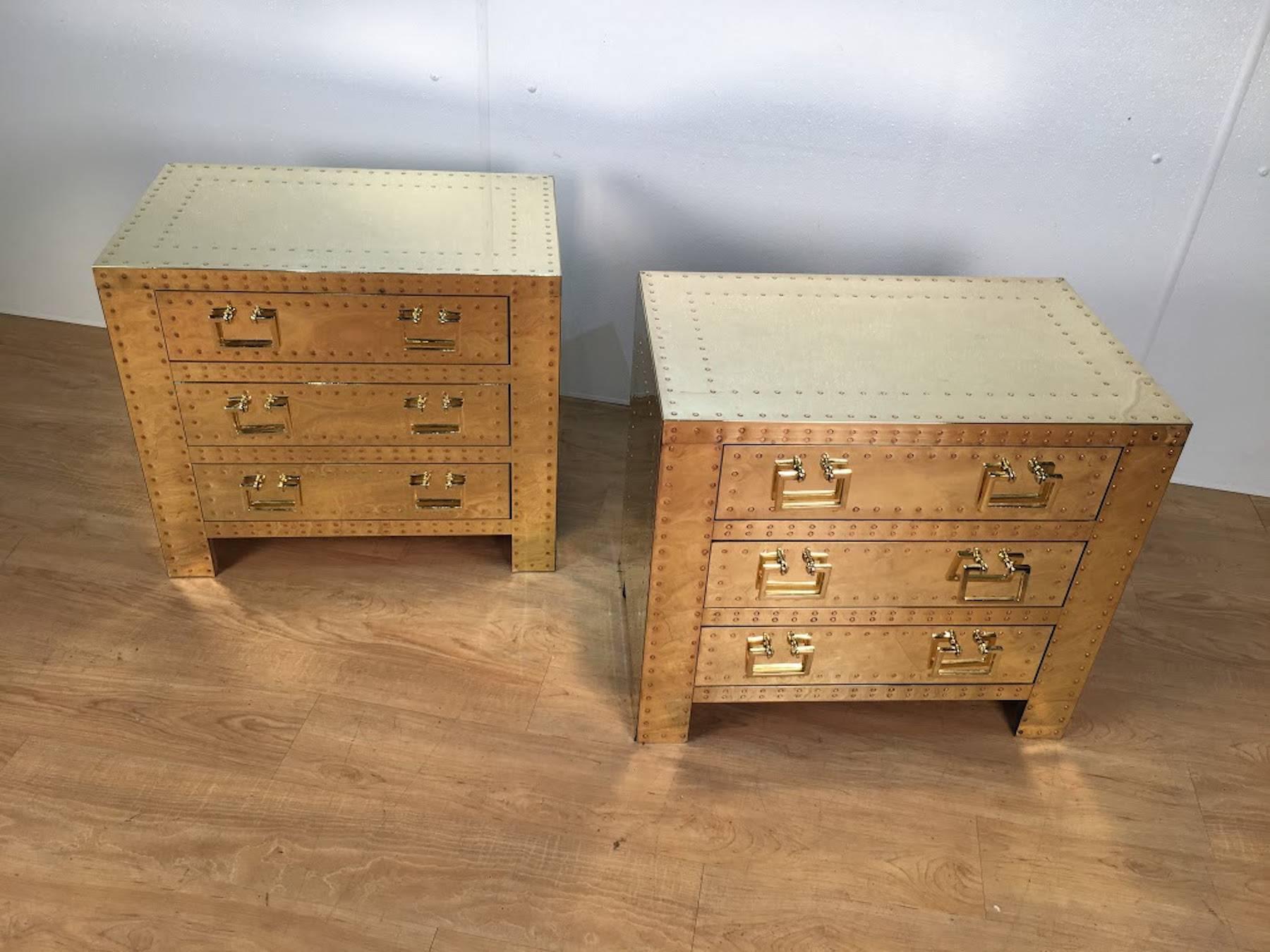 Pair of brass Campaign style chests or nightstands, each one of rectangular form with all-over inset brass studs. Fitted with three drawers with rectangular brass pulls.