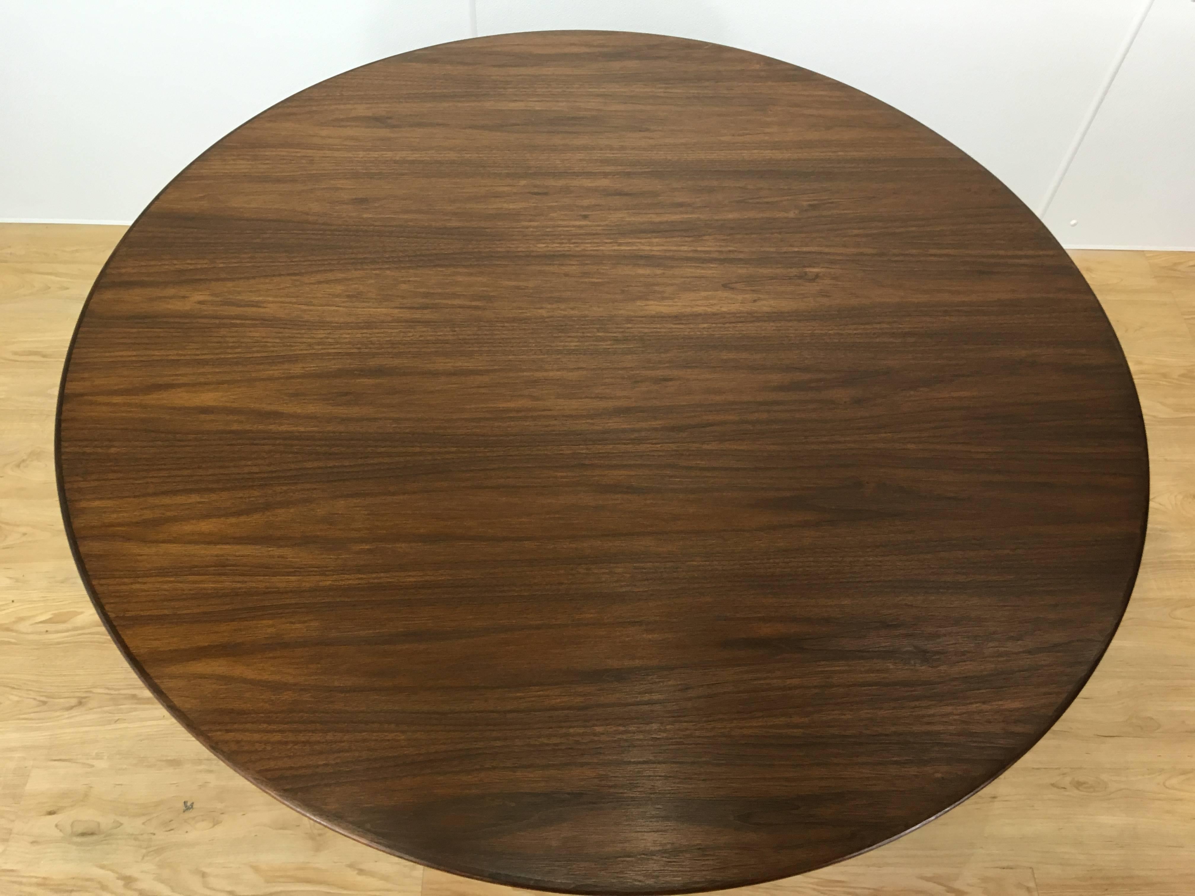 Eero Saarinen walnut dining table by Knoll, with 48 inch circular well figured rosewood top with beautiful inclined chamfered edge, raised on typical enameled aluminum weighted base.