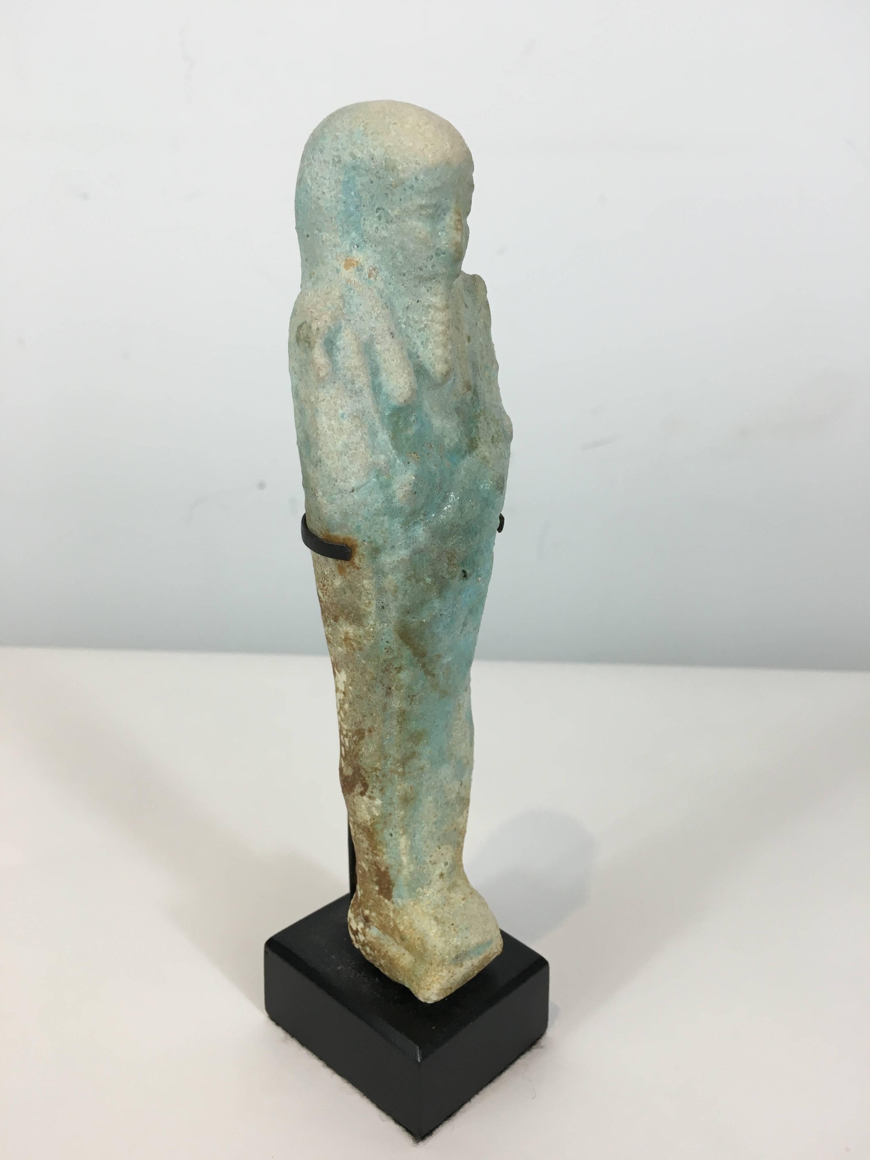 Egyptian Ushabti , a fine example of a Egyptian funerary figure, museum mounted. Ushabtis were placed in tombs among the grave goods and were intended to act as servants or minions for the deceased, should he/she be called upon to do manual labor in