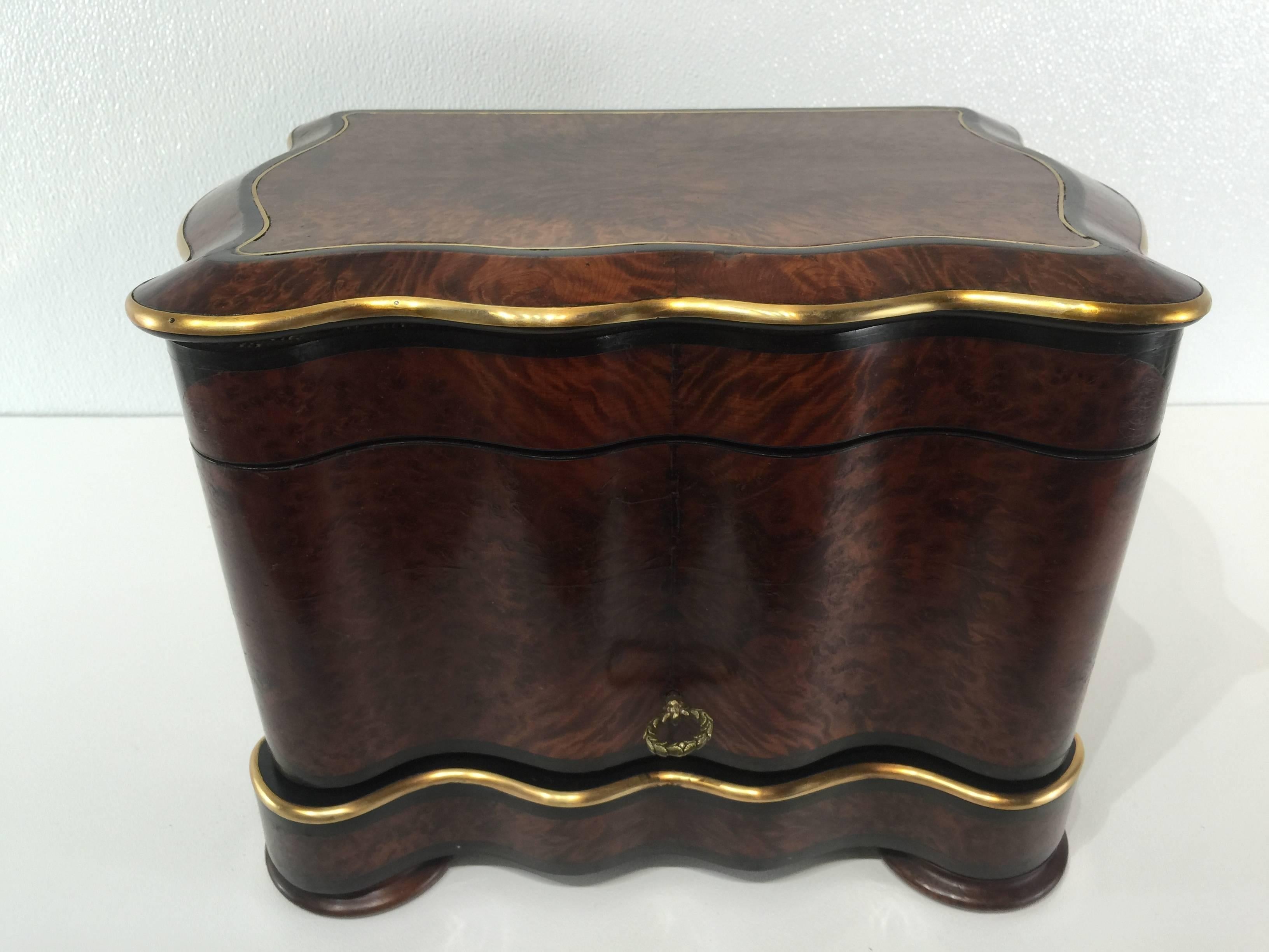 Napoleon III Tauntless, The case a serpentine carpathian burl and mahogany with inset gilt bronze mounts, when opened revealing a separate ormolu and rosewood caddy holding four decanters and and twelve cut crystal cordials , all in the style of