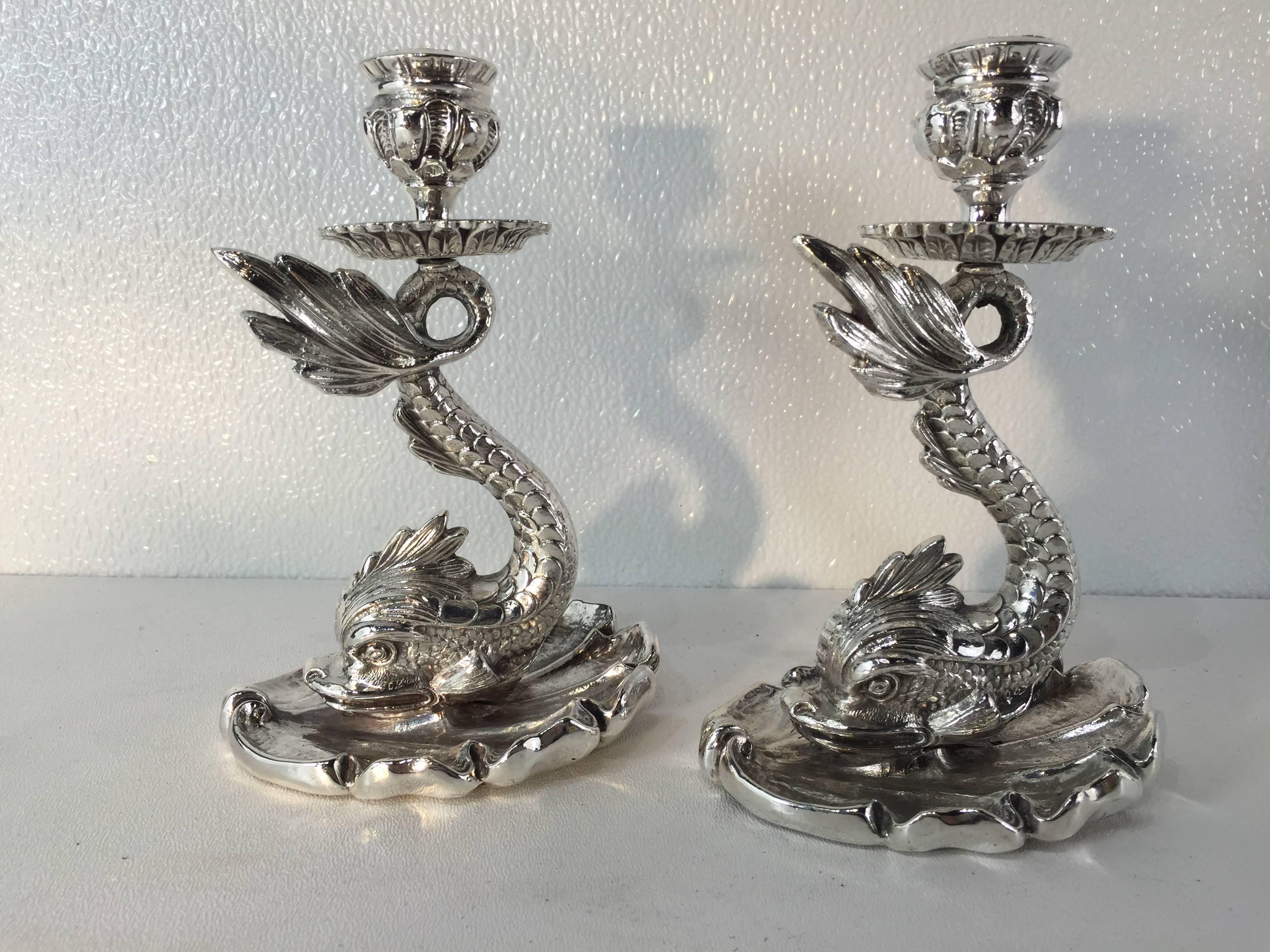 A pair of silver plated bronze dolphin candlesticks, of diminutive form each one finely cast recumbent dolphin on an oval shell base. Stamped 