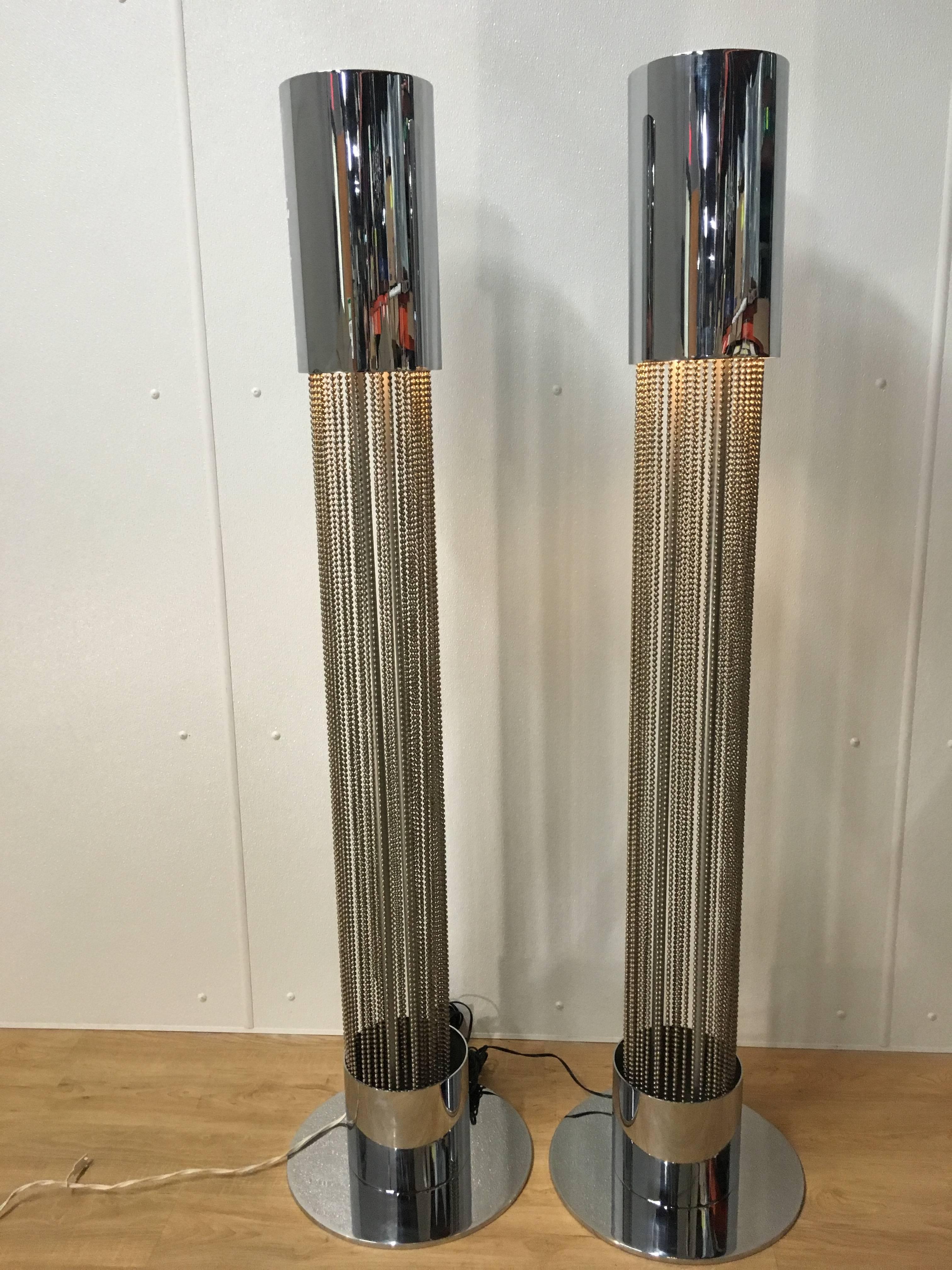 Pair of chrome floor lamps by Pierre Cardin. Each one of circular pedestal form with hanging acid washed steel ball chain, resting in conforming platform base. Chrome is in triple mint condition, wiring is new.