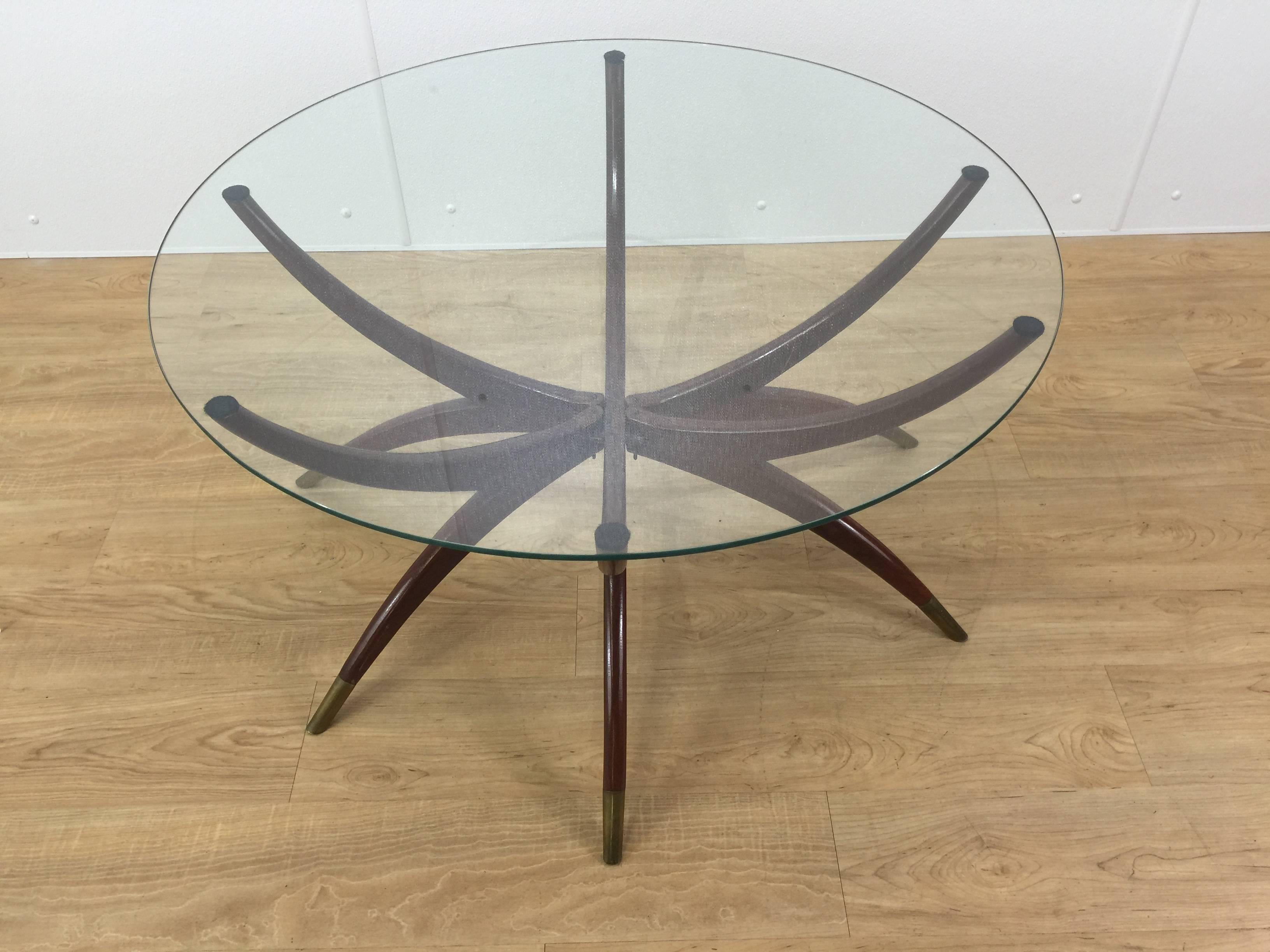 Mid-Century Modern spider leg coffee table, of typical form with circular glass top on collapsible wood and brass sabot mounted base. When collapsed the base measures 34