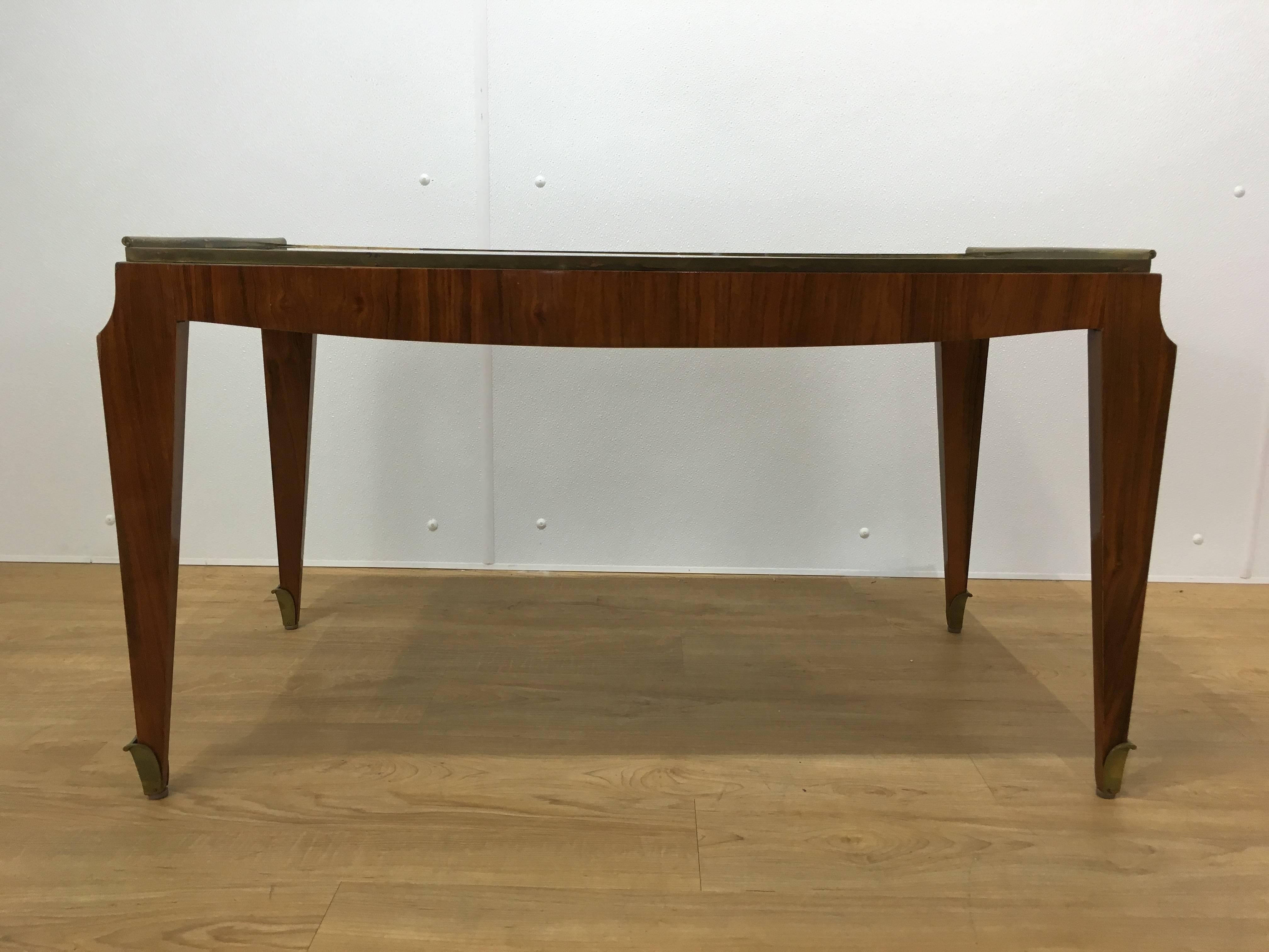 Fine Art Deco coffee table of rectangular form with inset intentionally distressed mirrored glass top raised on a well figured mahogany base with exaggerated brass sabots.