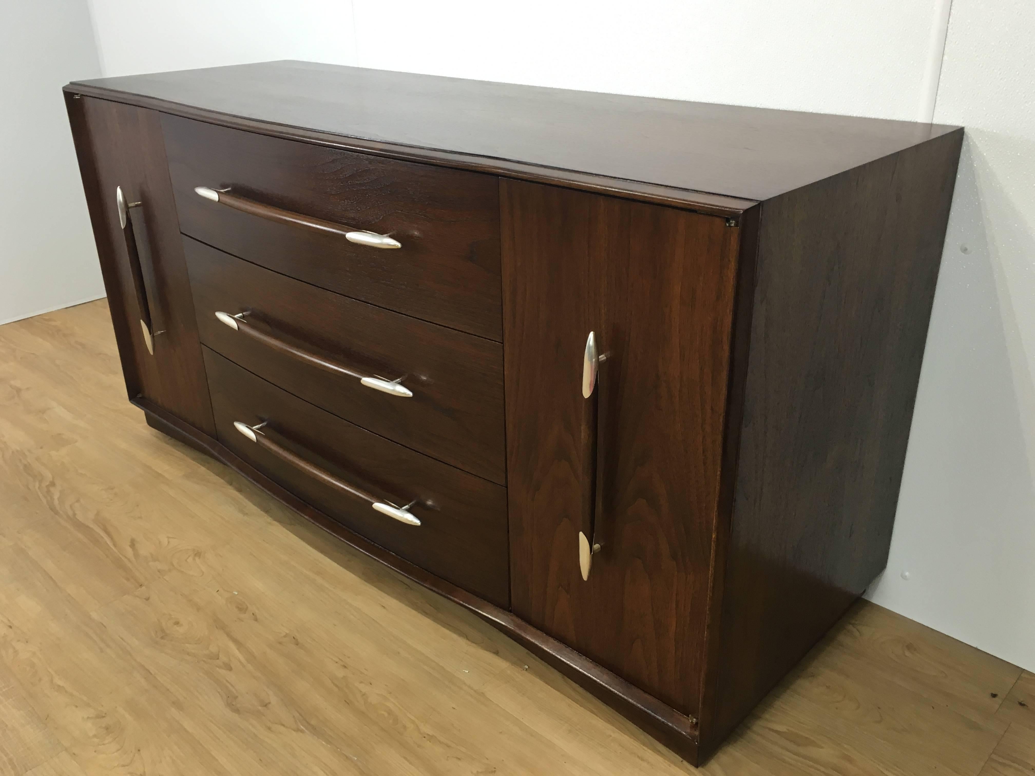 T.H. Robsjohn-Gibbings sideboard, rare form with two large doors flanking three centered long drawers with original silverplated hardware. Expertly finished. 