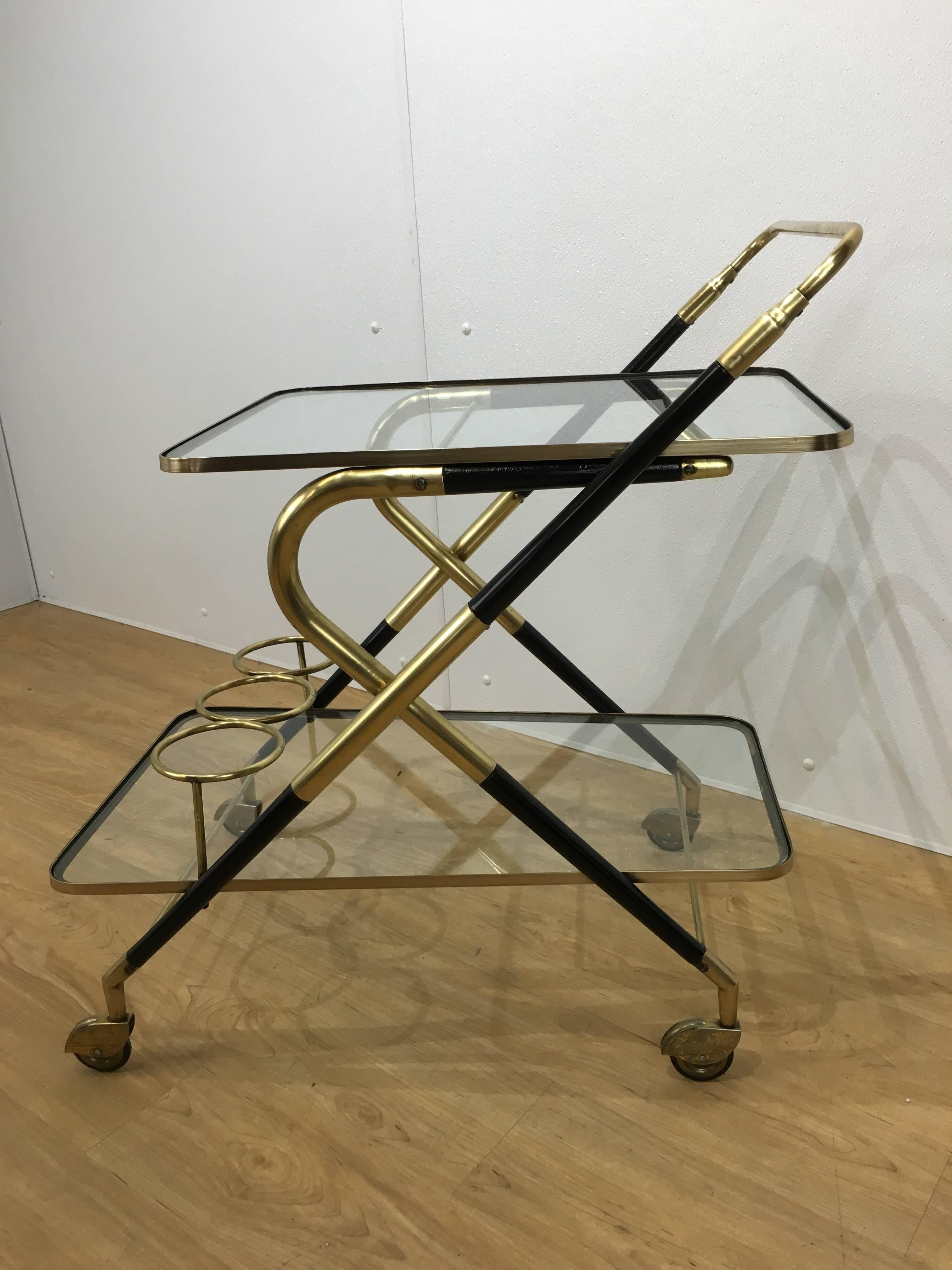 Italian brass and ebonized wood bar cart, of tapering sculptural form with two tapering glass tiers.