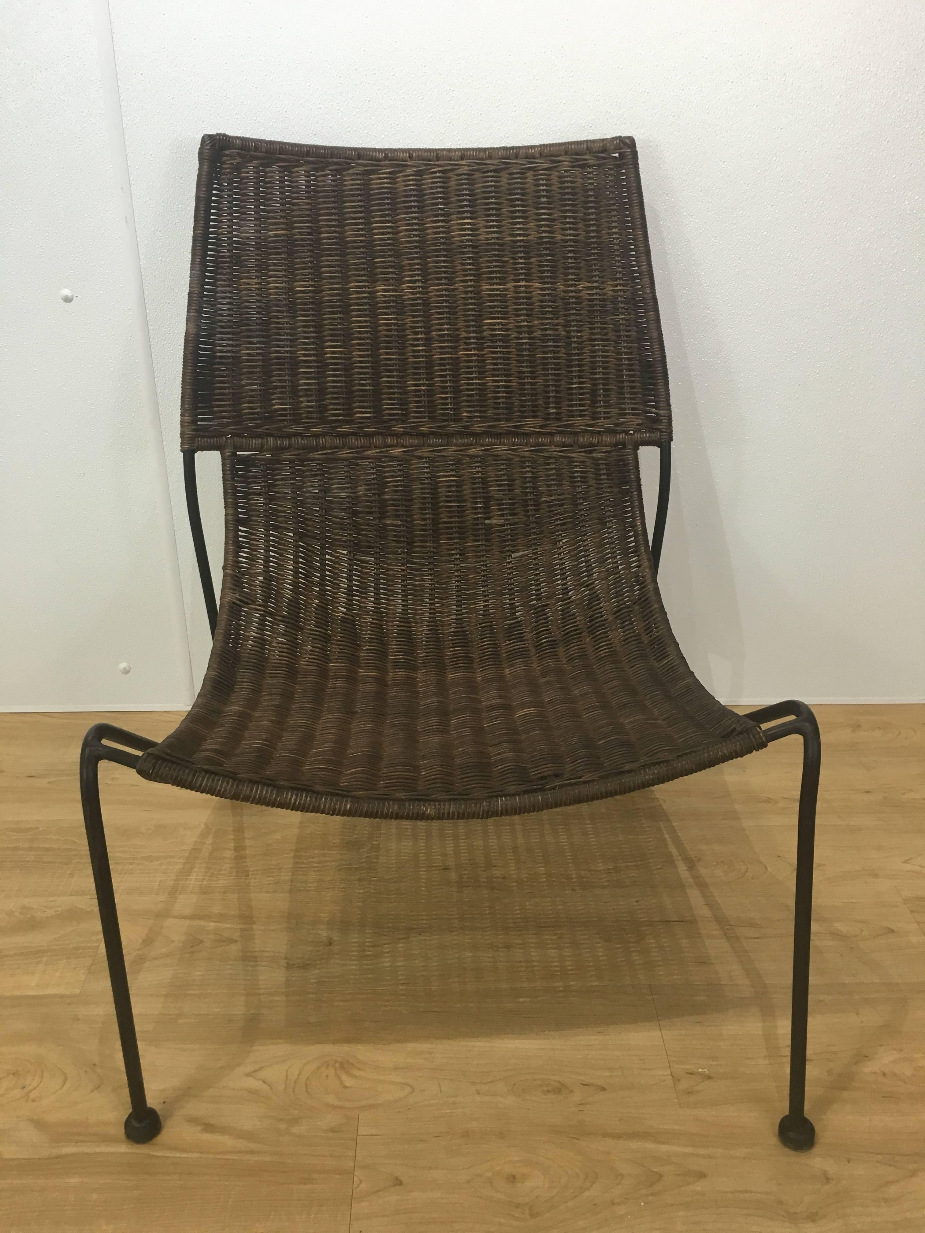 Sculptural rattan lounge chair, finely woven on stylized ebonized iron base.