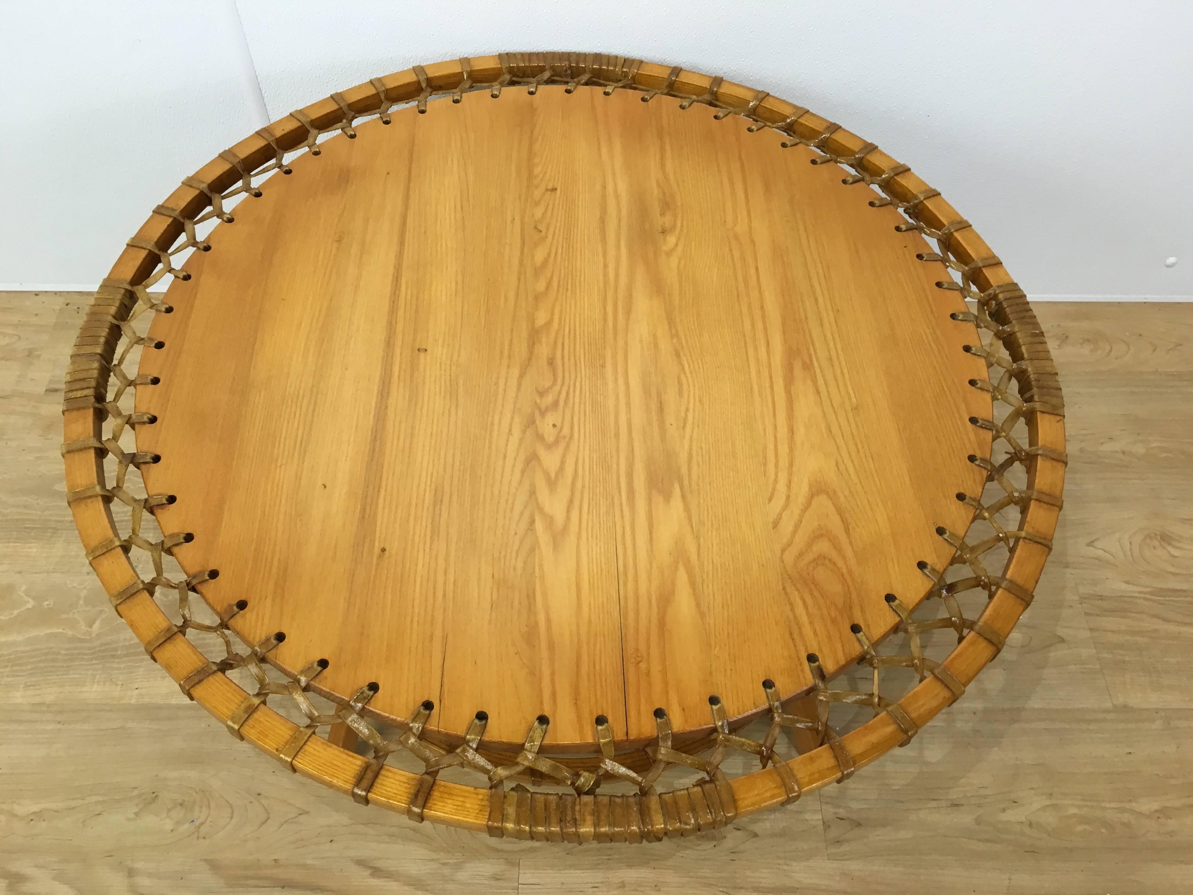 Circular oak Adirondack style coffee table with woven raw-hide detail and lower shelf.
Near pair available, please see fifth detail photo. Minor variations in wood top but present well together. Please contact us for further details.