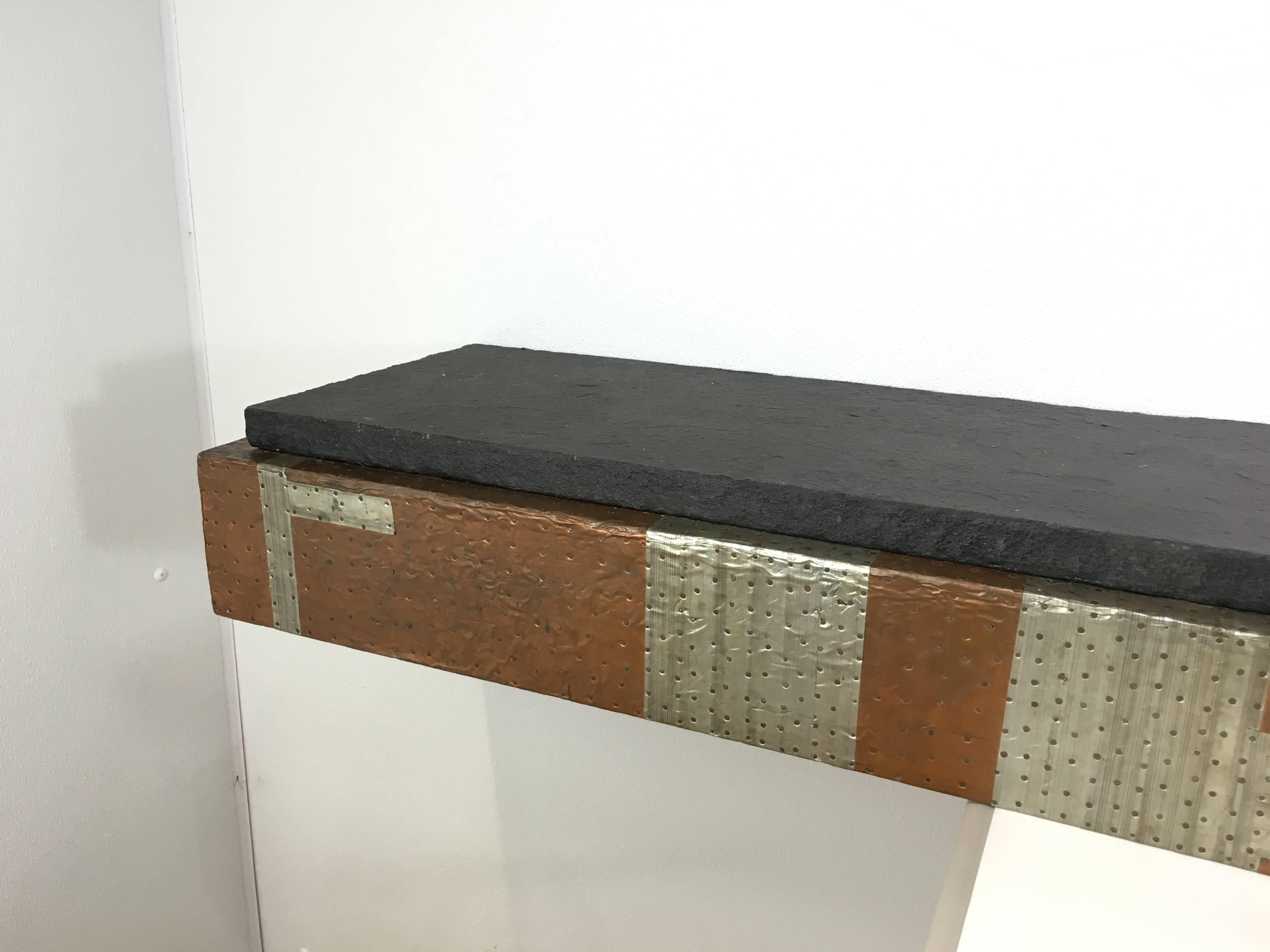 Large Paul Evans floating console, 8 feet in length, Wall-mounted console of patchwork patinated metals with conforming slate top. Measures: 96