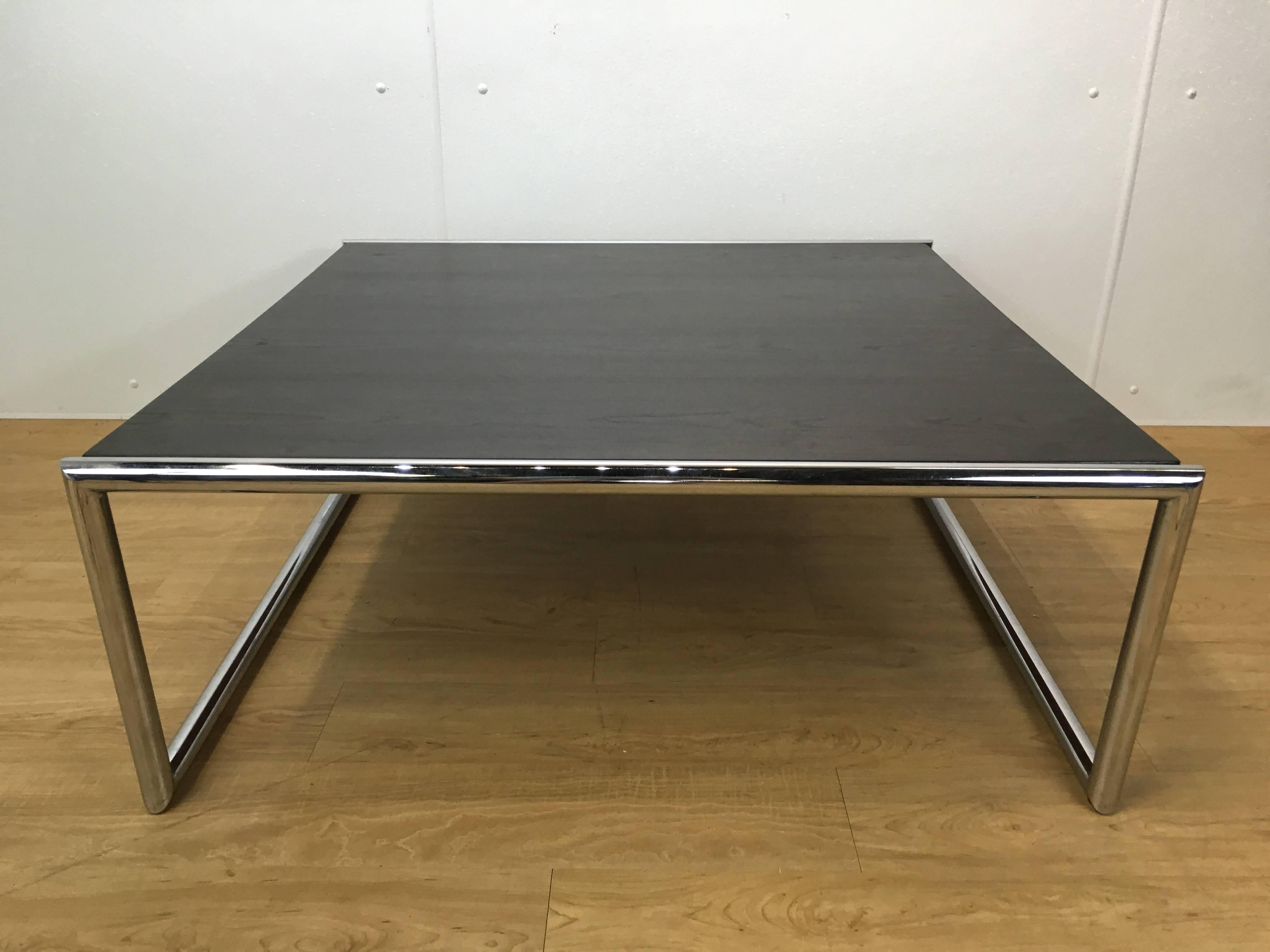 A large ebonized mahogany and tubular chrome cocktail table. Great finish to the wood top showing the beautiful grain. Great scale and proportions.