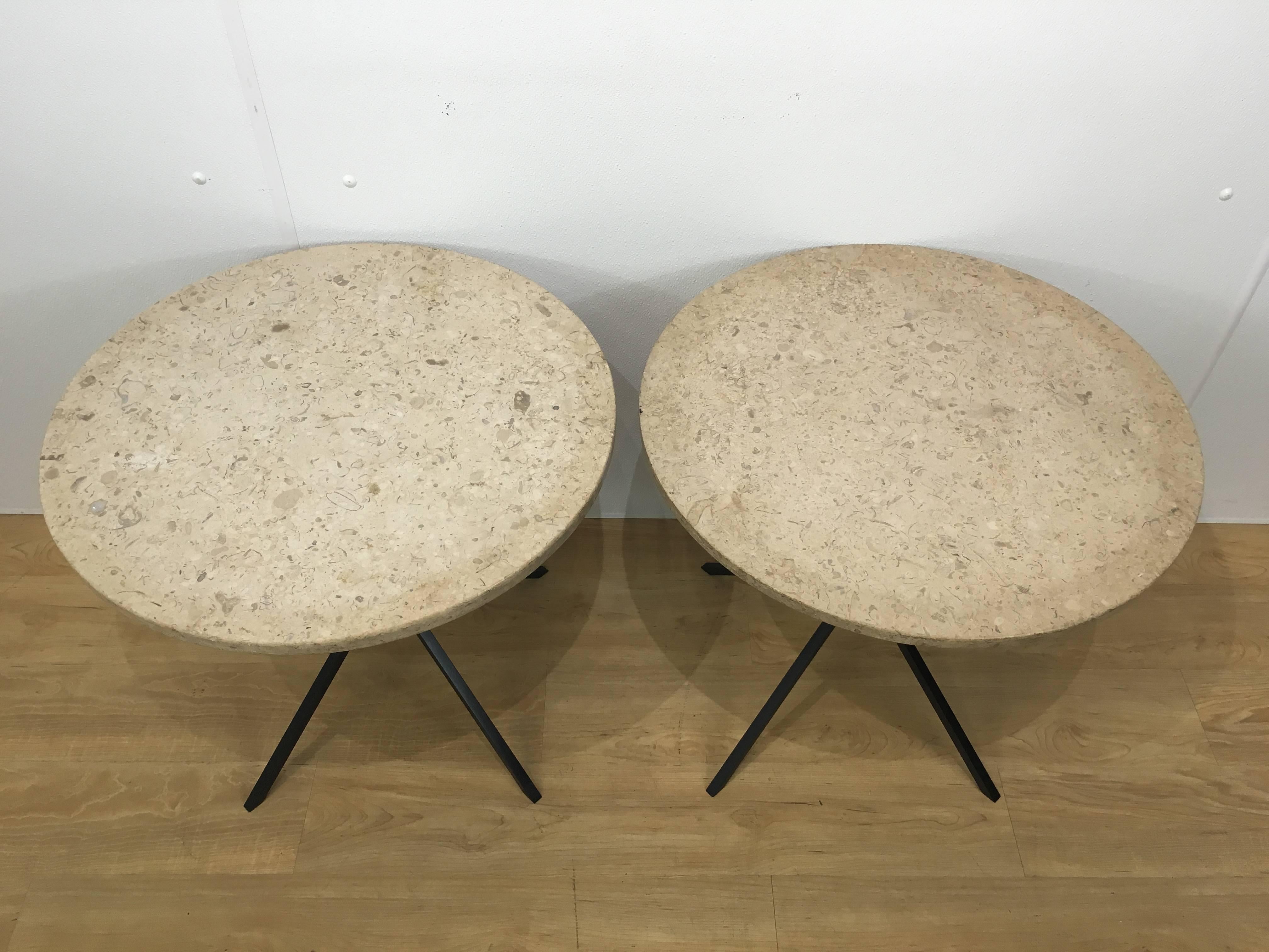 A pair of Italian modern black metal base side tables with circular travertine top supported by four knotted legs.
