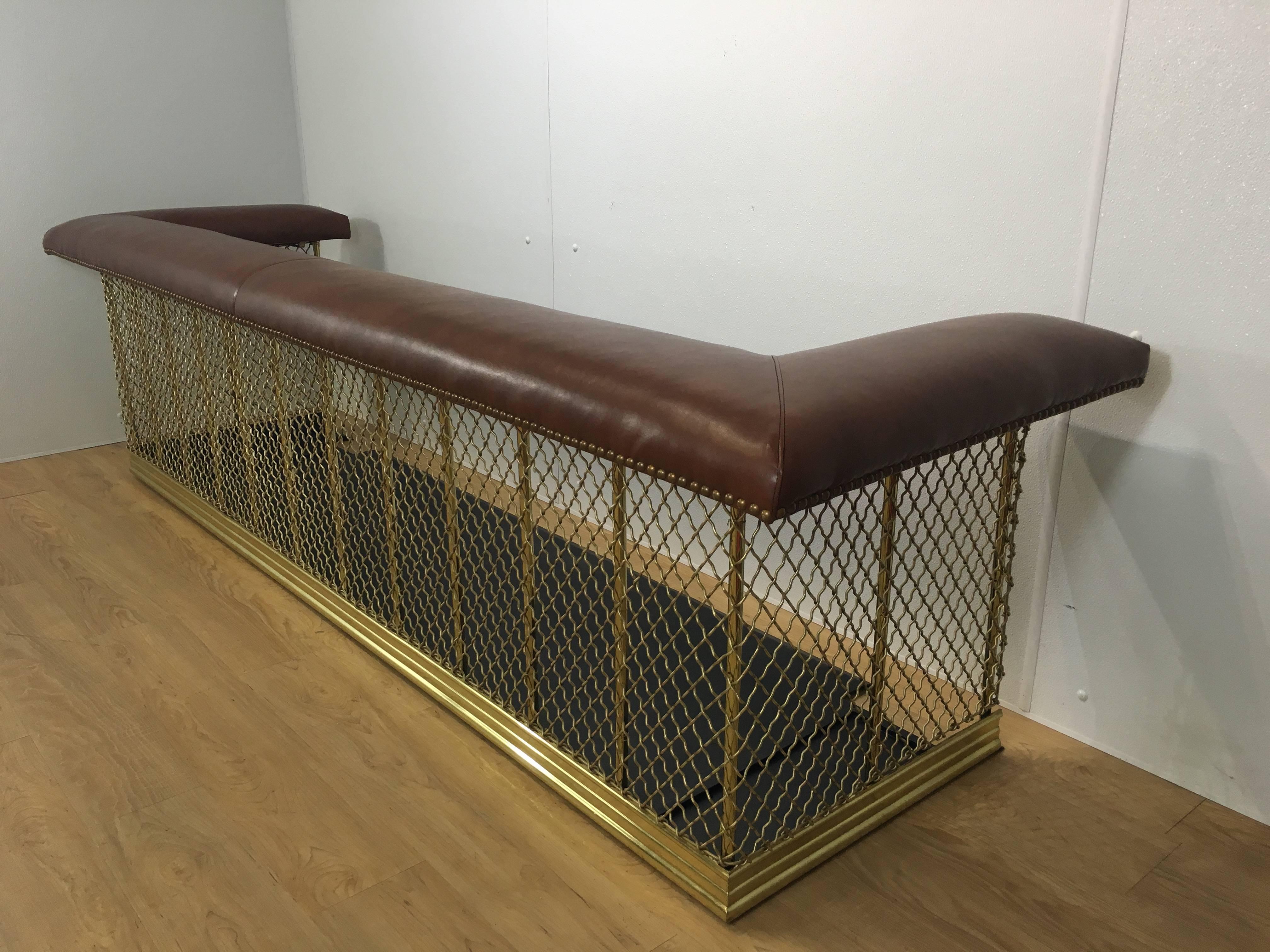 Monumental (over seven feet long) 19th century English brass and leather club fender with newly upholstered leather cushion and interior brass hooks for tools. Finely cast brass wire mesh surround with columns mounted on cast iron platform.
Two