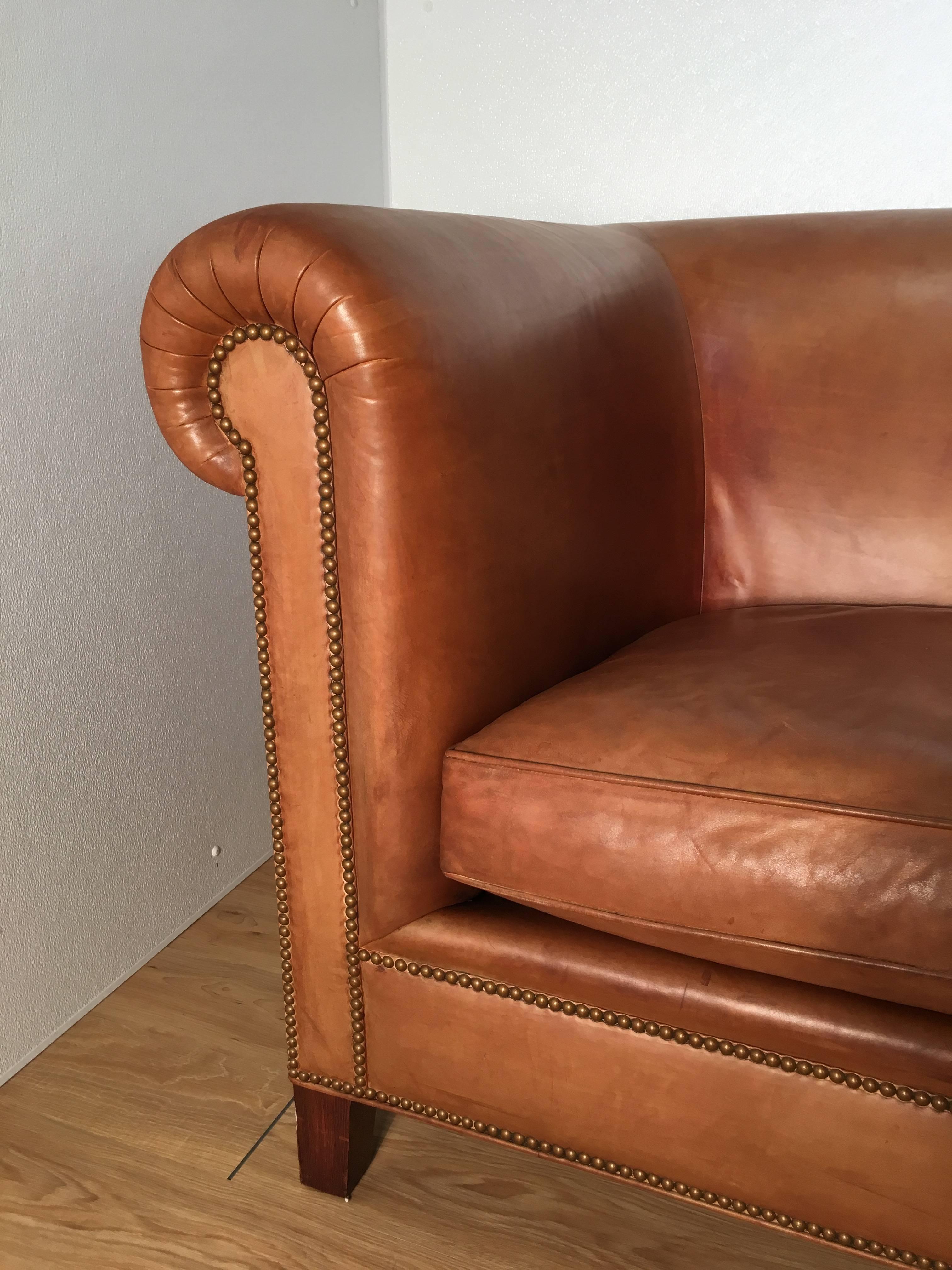 Stunning saddle leather English rolled arm Chesterfield sofa. Large-scale with great depth, beautiful patina on leather.