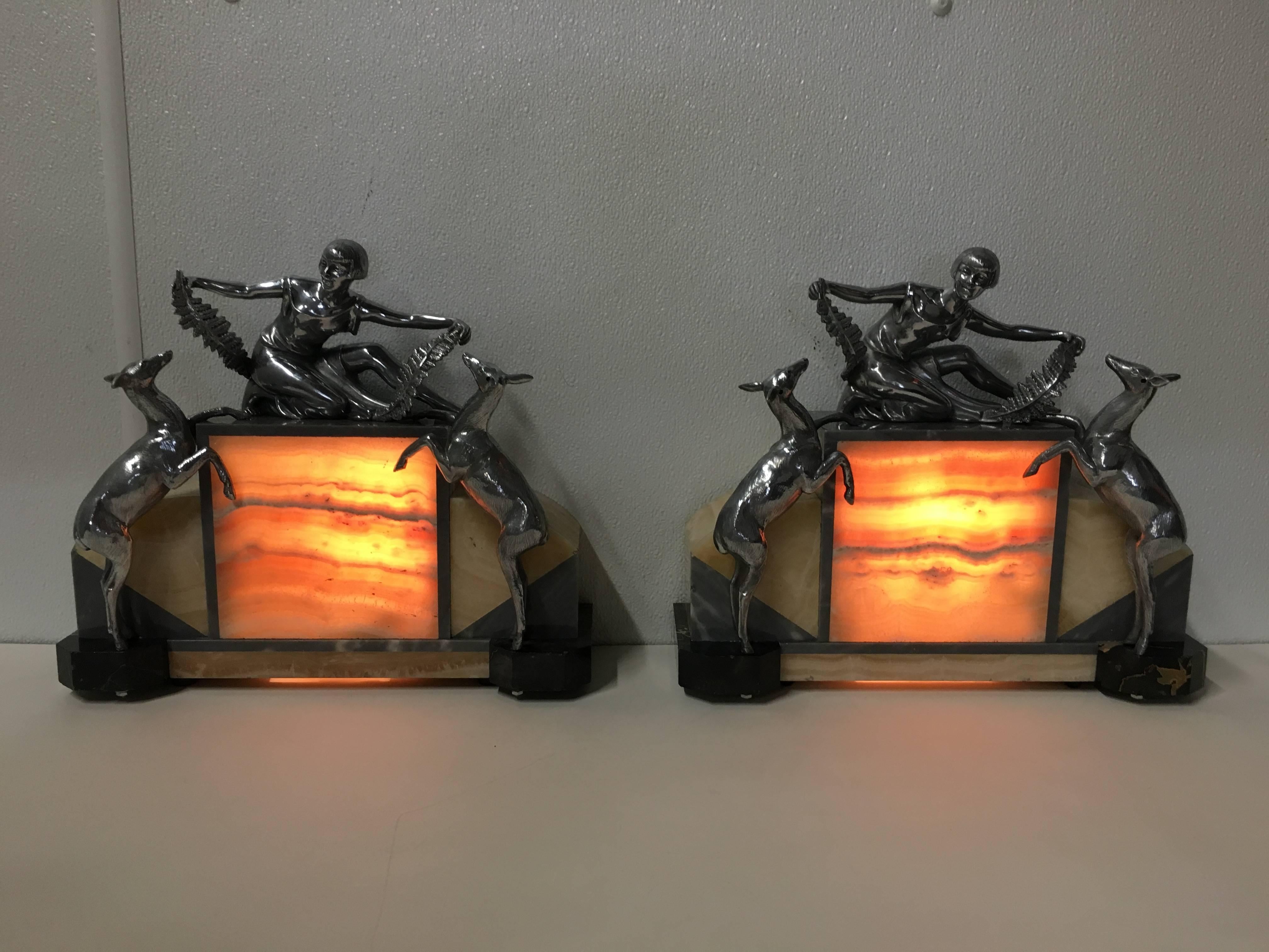 Pair of Art Deco figural lamps, in the style of Demétre Chiparus.
Each one with seated figure with deer, on marble and variegated onyx illuminated bases. Unsigned. Beautiful quality, exceptional when illuminated.
 