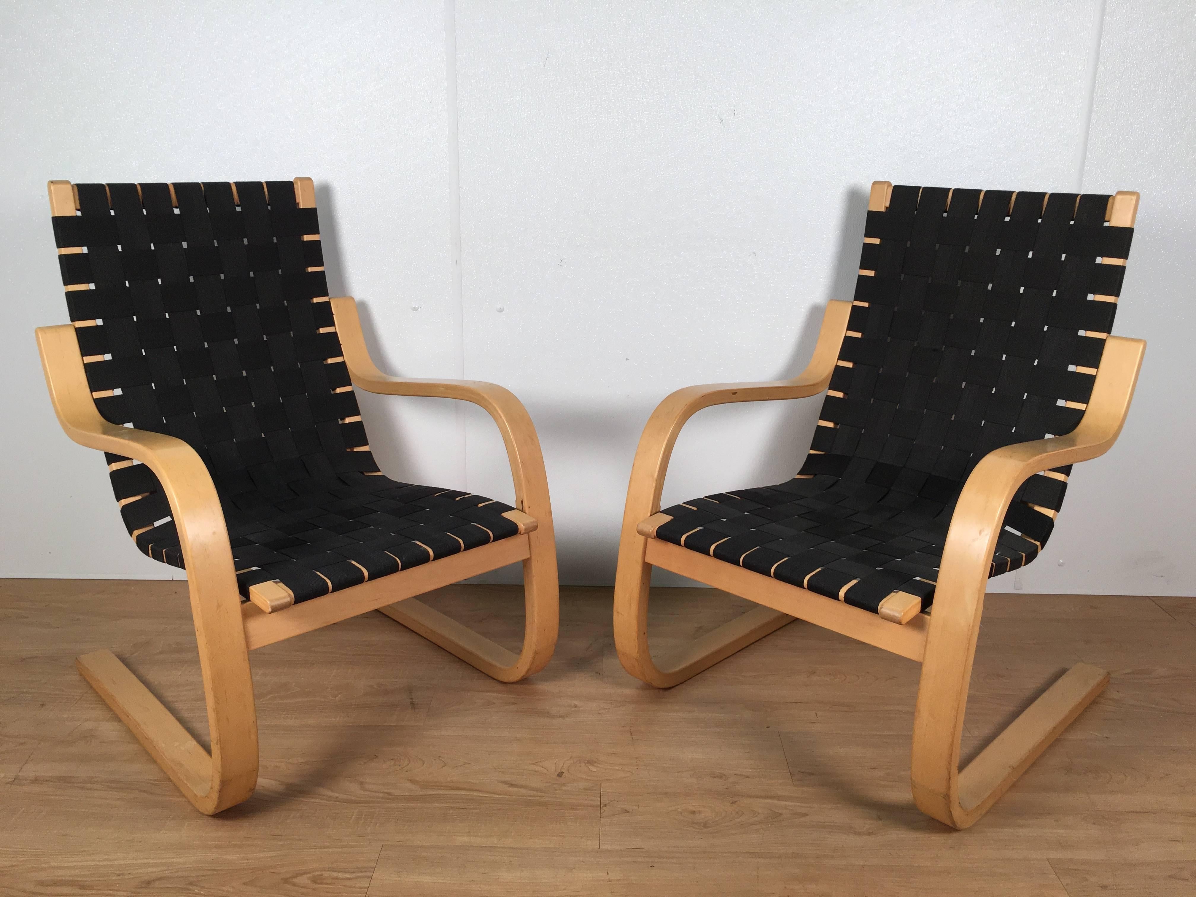 Pair of Alvar Aalto #406 lounge chairs. Each one of typical form with woven black fabric and sculptural bentwood birch frame, by Artek, IFC.
   