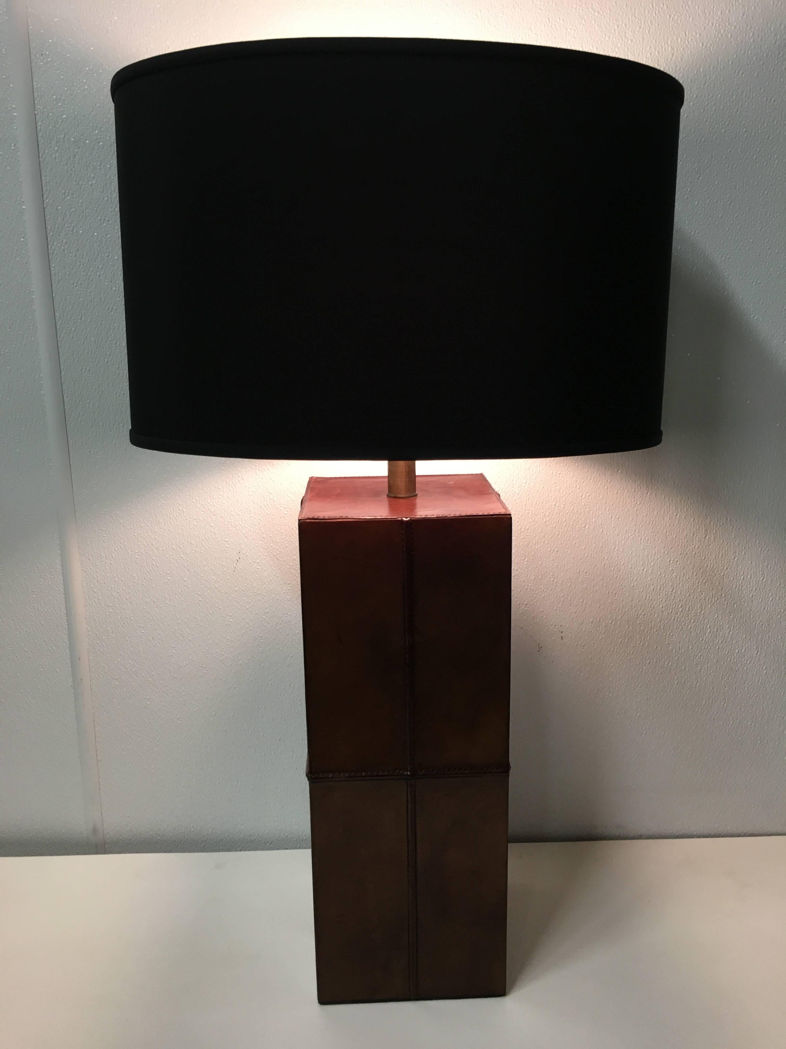 Handsome pair of stitched leather table lamps, in the style of Jacques Adnet. Great patina to rich brown leather with oil rubbed brass fittings. Shade and harp for display purposes only.