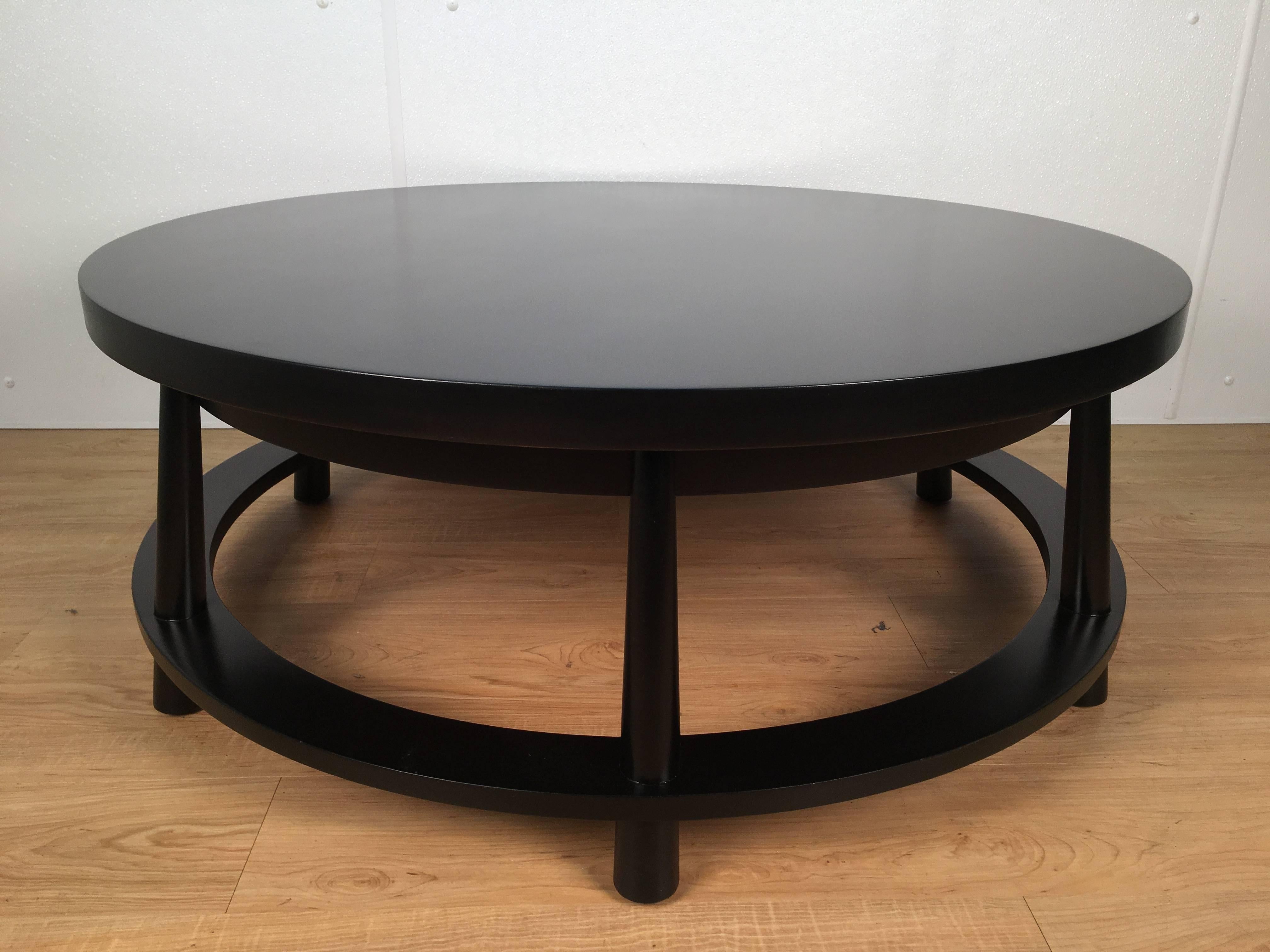 Rare ebonized two-drawer round cocktail table by T.H. Robsjohn-Gibbings for Widdicomb. All around ebonized wood with two concealed drawers. Last image is a original 1951 Widdicomb ad showing this table. We also have a pair of the 1651 Spindle lounge