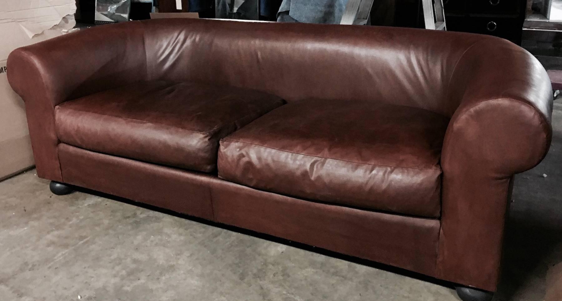 Large Ralph Lauren brown leather modern Chesterfield sofa, with rolled arms
sleek unstuffed sofa with two large seat cushions raised on four ebonized bun legs. A solid choice for the living room, library, large bedroom or any room in your house