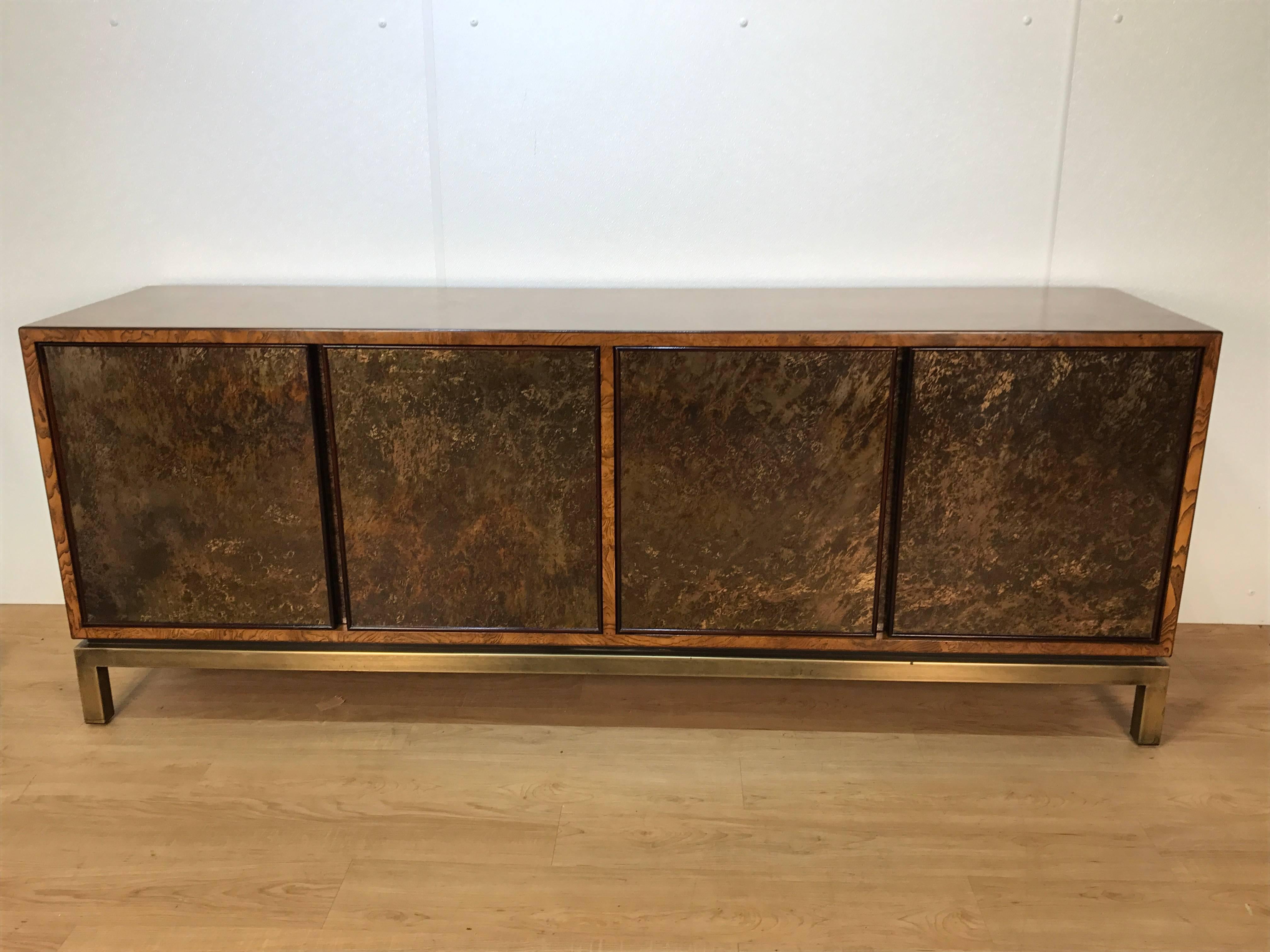 Stunning acid washed bronze sideboard by John Widdicomb, of rectangular form, the burled elm case is fitted with four concealed acid washed bronze doors raised on a patinated brass Campaign style base. Expertly finished.






