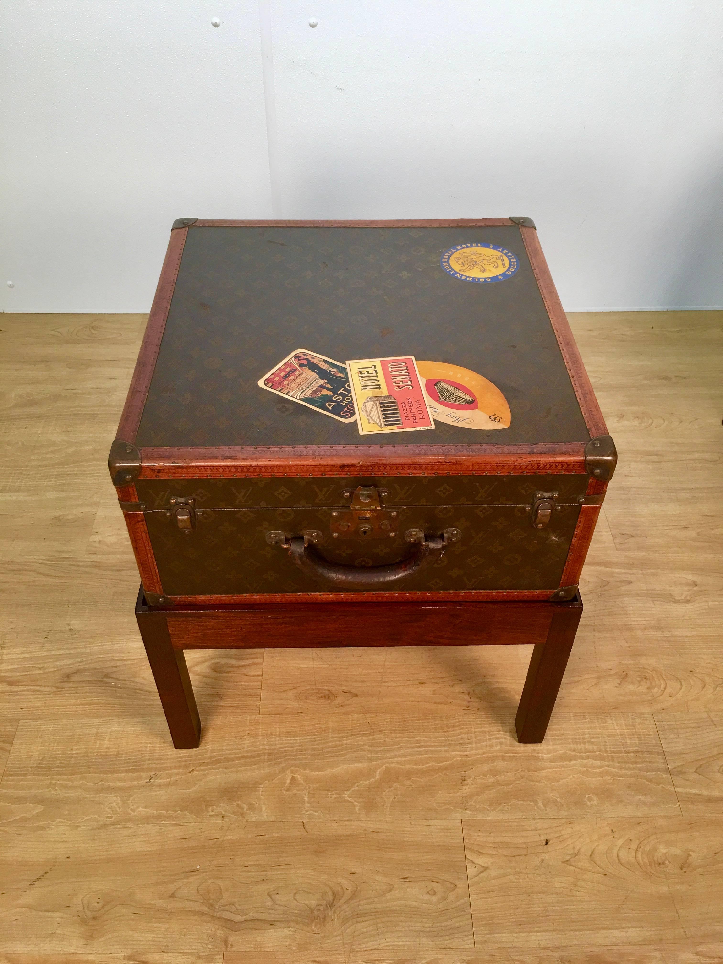 Louis Vuitton steamer trunk on stand, unusual square shape.
The 20.25" square hard case with numerous vintage travel labels and monogram of "K.D.P New York" raised on a custom mahogany stand. 
If desired we can have our conservator