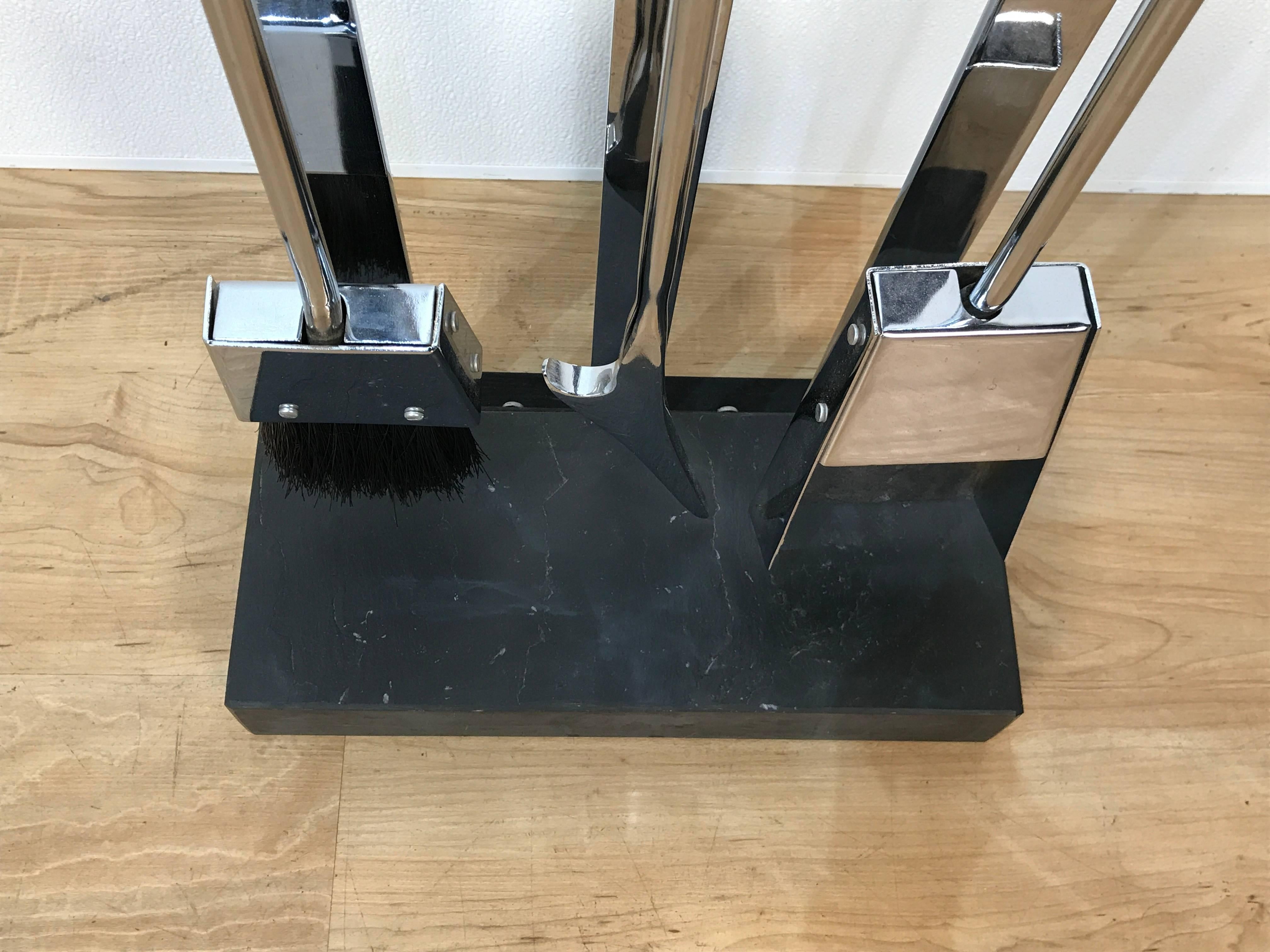 Minimalist Mid-Century chrome and slate fireplace tools by Alessandro Albrizzi, consisting of a shovel, brush, and poker, raised on a rectangular slate pedestal base. This item is located at our Atlanta location, not NJ.