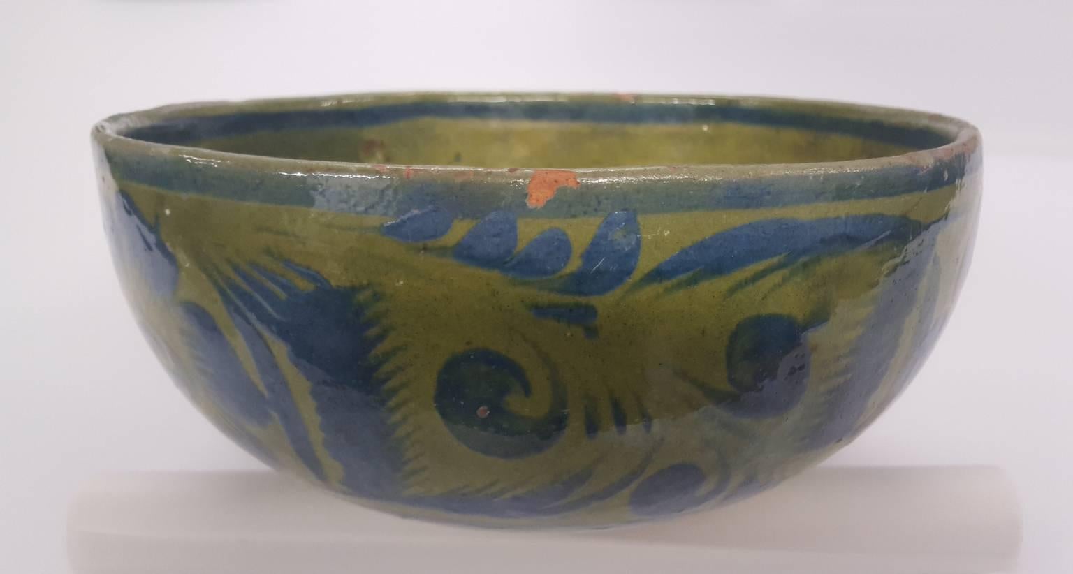 A vintage glazed Mexican pottery bowl in blue and green. It is in good condition but has a chip at the rim and minor losses in small spots during glazing. It is a charming decorative object with a Folk Art appeal.