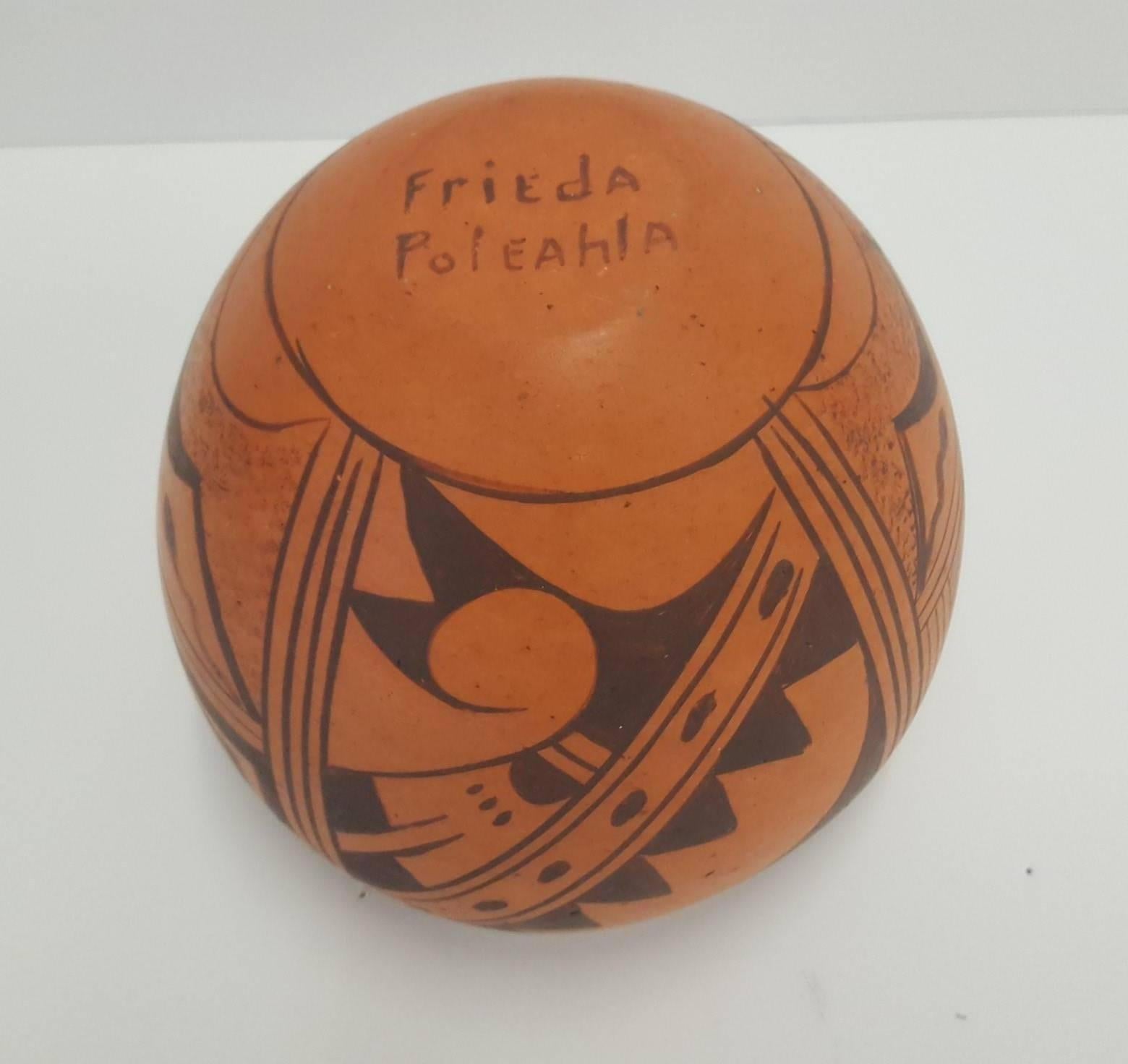 A small, red clay bowl, painted with black graphic designs, created by Hopi potter, Frieda Poleahla circa 1960.
This pottery bowl was purchased at Walpi Village, First Mesa, Hopi Reservation by the current owner in 1982.
The piece is in excellent