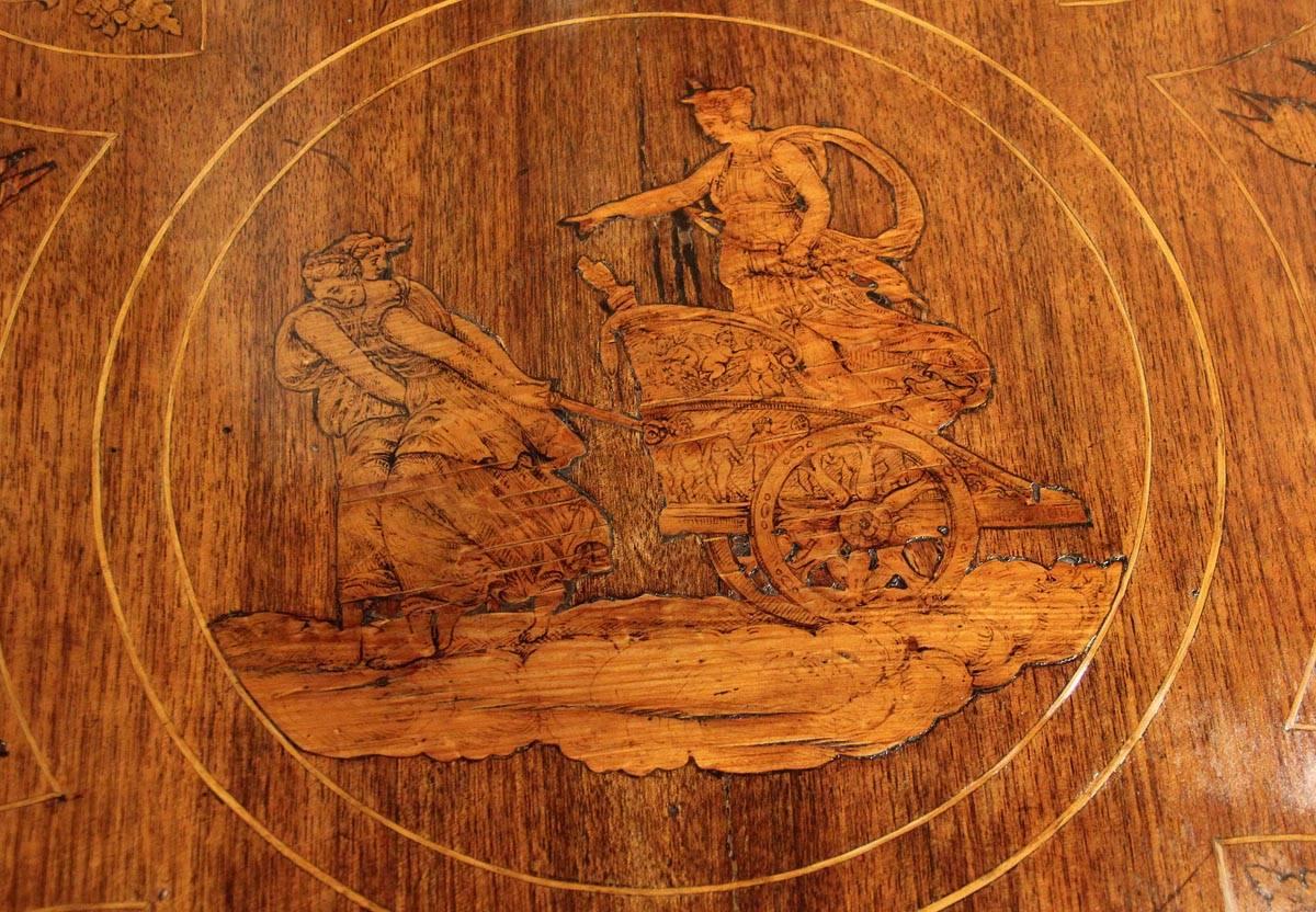 An 18th century Milanese marquetry center table, the top featuring the Goddess Diana holding a bow and riding in a chariot, with one drawer decorated with two swans flanking an urn, the whole atop four squared and tapering legs terminating in lions