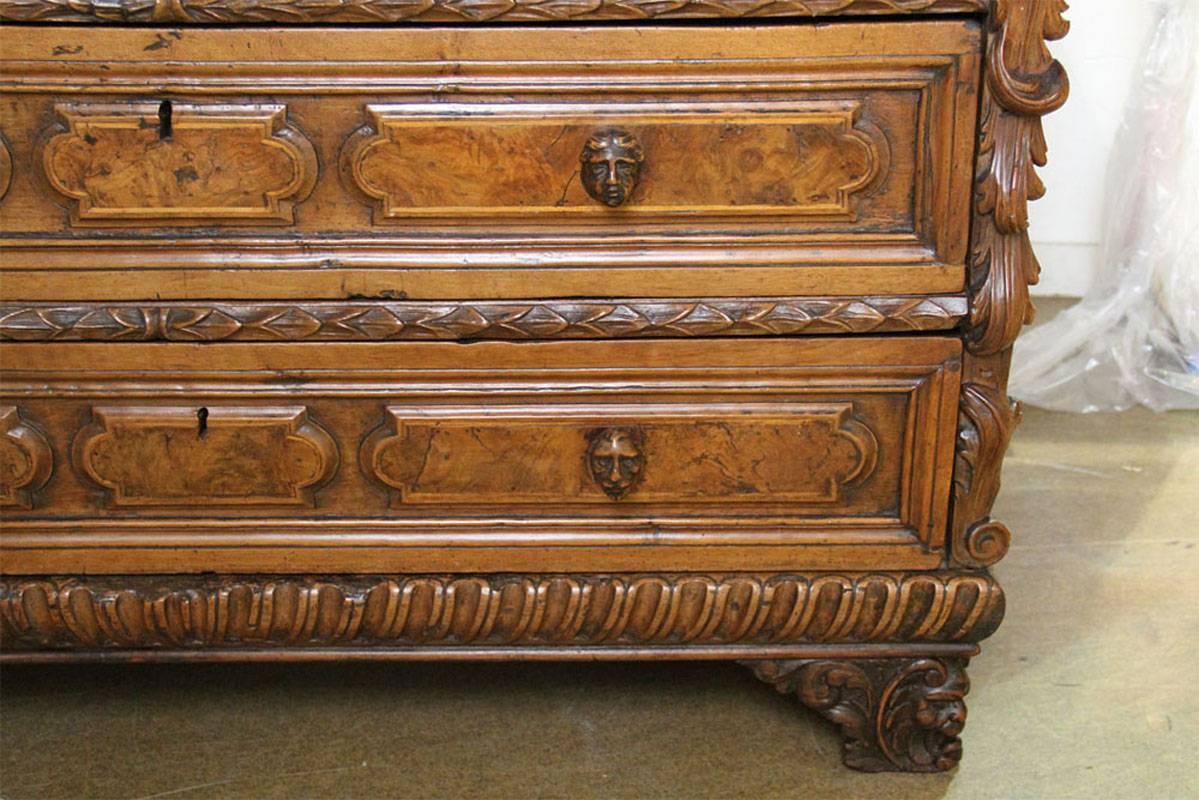 A late 17th century florentine walnut chest of drawers.
The three drawers fitted with carved masque knobs of the titled males in the family that commissioned the piece, the front corners embellished with carved alto relievo angelic faces above