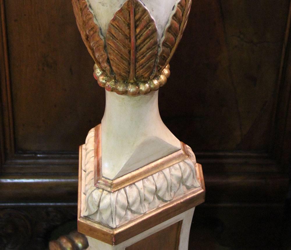 From the Mariani Privé Custom Workshop, An Italian Style Polychrome and Parcel Gilt Torchère Floor Lamp, in cream polychrome and giltwood accents, carved with foliate motifs, and raised on a tripod base with stylized lion paw feet and fitted for
