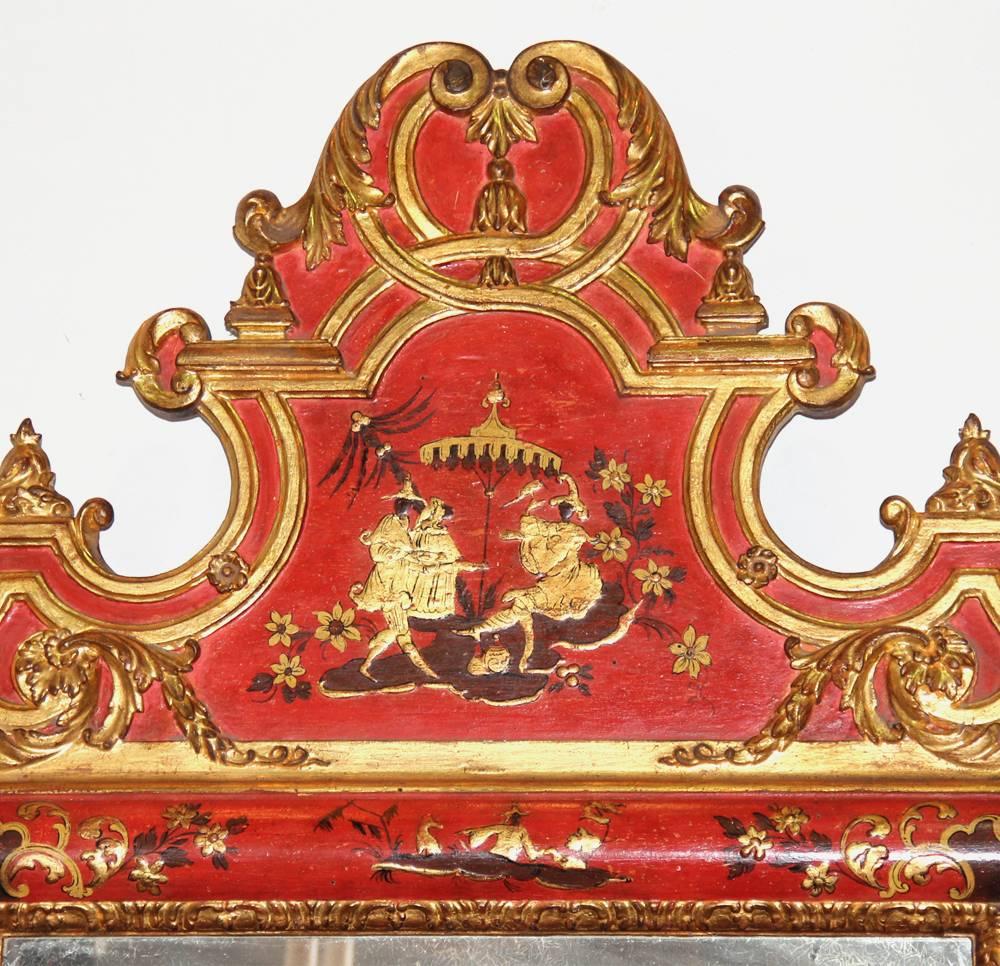 A striking pair of late 18th century Italian parcel-gilt and polychrome red lacquer chinoiserie mirrors, the original mirror plates crested by fanciful parcel-gilt tops carved with acanthus leaf motifs and centered by playful aristocratic figures,