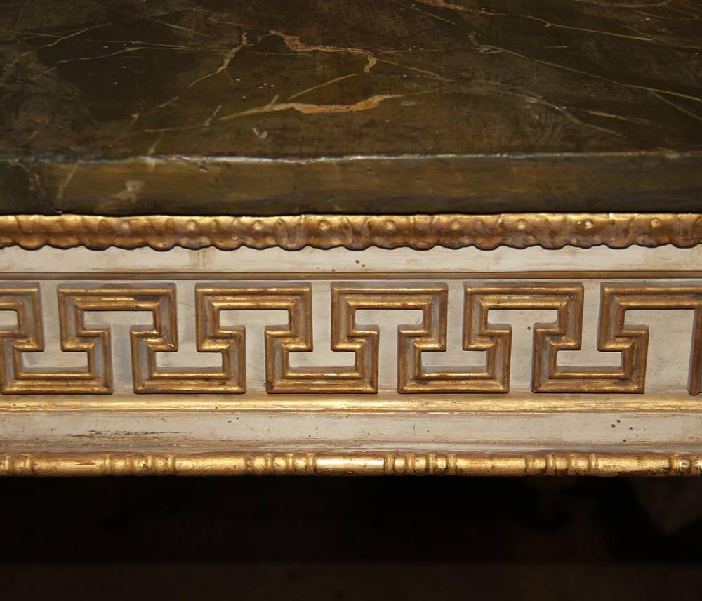 An Important pair of 18th century Italian Louis XVI polychrome and parcel-gilt console tables, the apron accented with Greek key "Meander" pattern, fluting, and centered by a floret, with the whole above squared tapering legs terminating