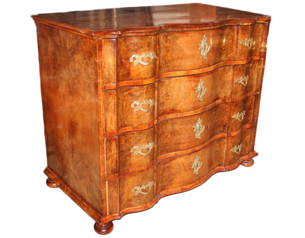 An unusual 18th century Dutch burl walnut arbalette commode with four functioning drawers, each embellished with gold ormolu Rococo pulls and escutcheons, the whole raised on flattened bun feet.