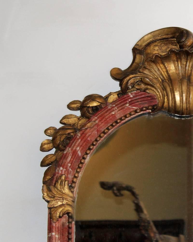 An 18th Century Italian Polychrome and Parcel-Gilt Mirror retaining the two original mercury glass plates, and giltwood rocaille frame motifs accenting a rose and white polychrome ground.