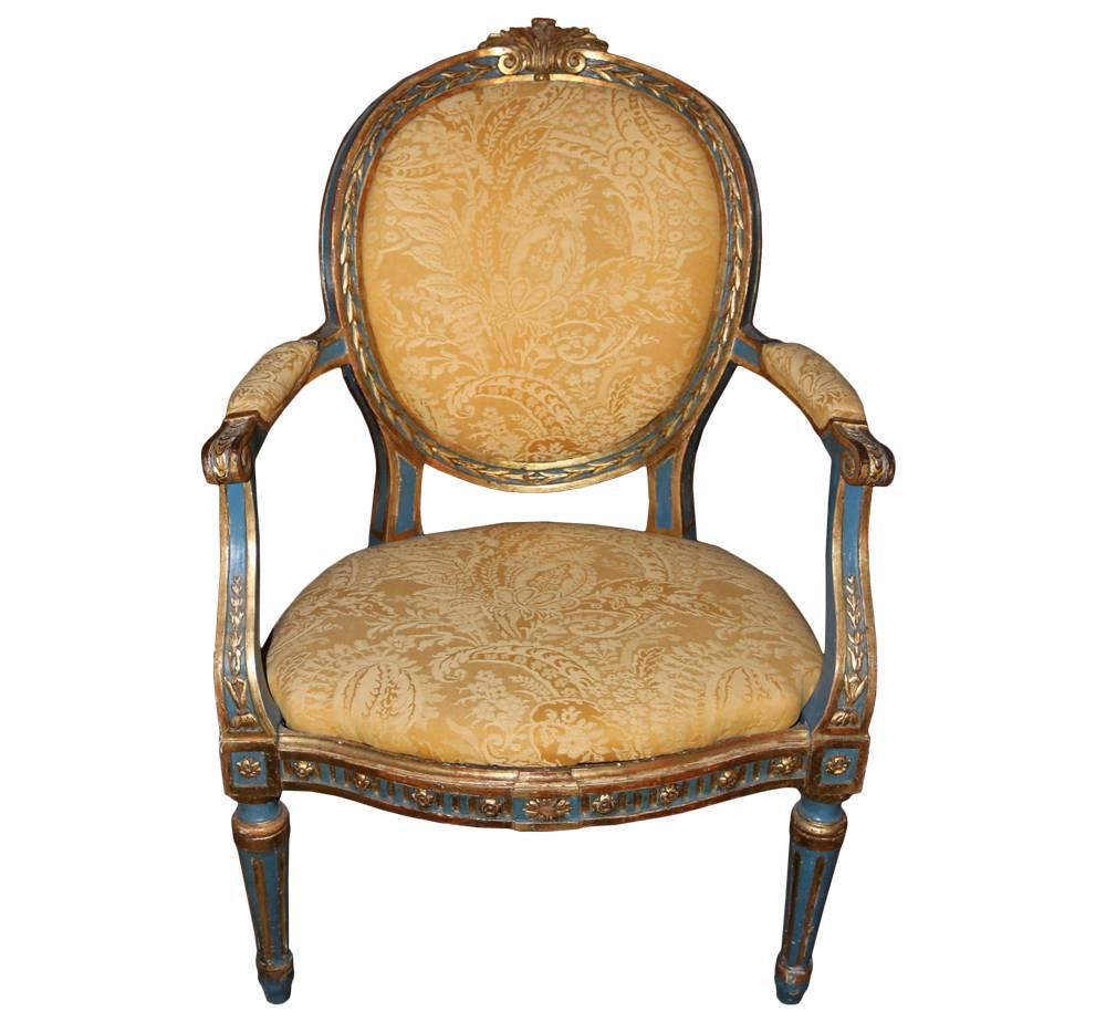 A set of six 18th century Italian Louis XVI fauteuils, each with oval upholstered backrest carved with leaf tips and acanthus leaf carved top rail, the padded armrests raised on voluted supports above a bowed seat raised on circular tapering fluted