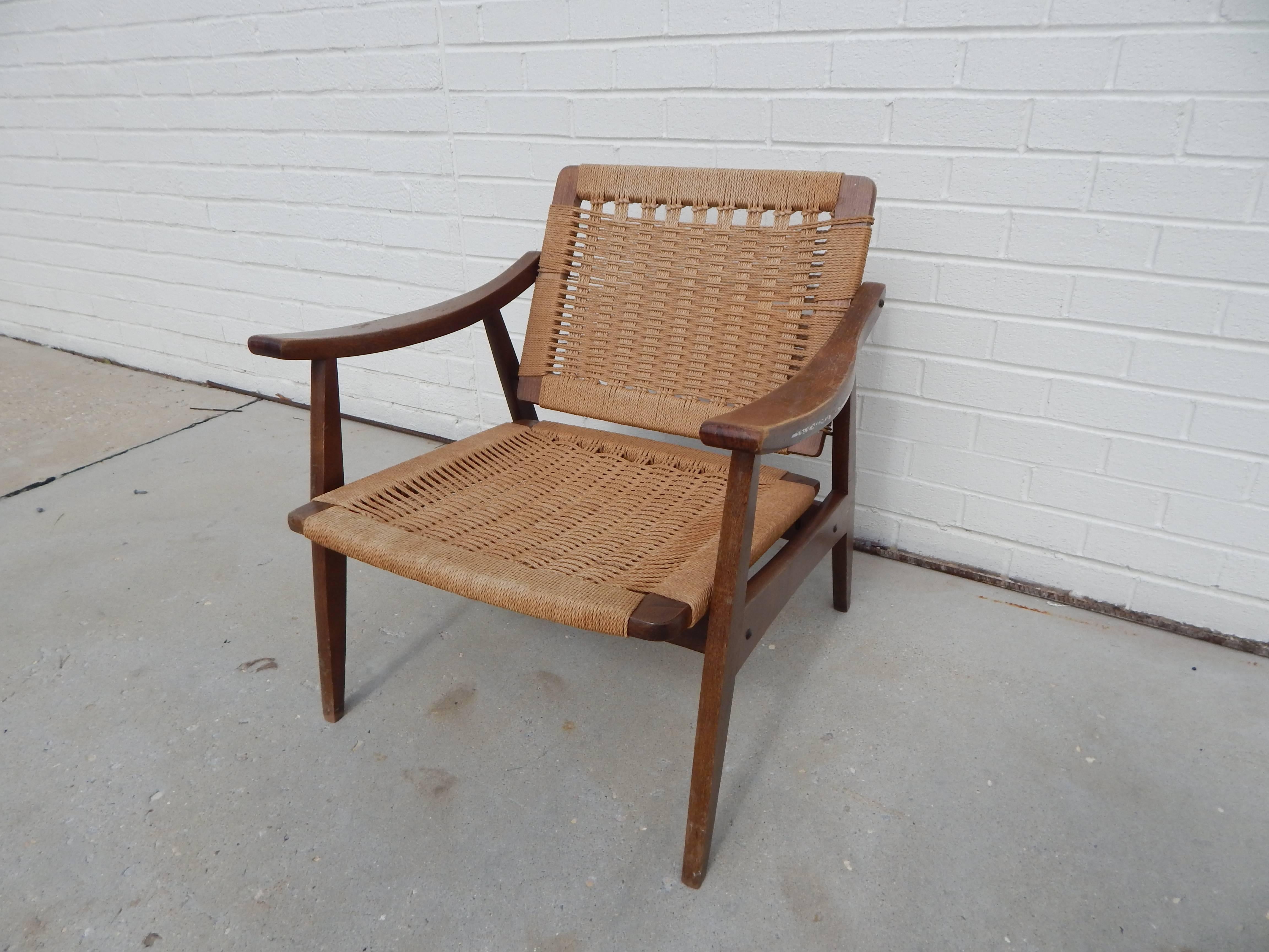 Mid-Century Hans Wegner style woven chair. Wood frame. Adjustable back. Rope weaving is in excellent condition wood frame shows some wear consistent with age and use.
