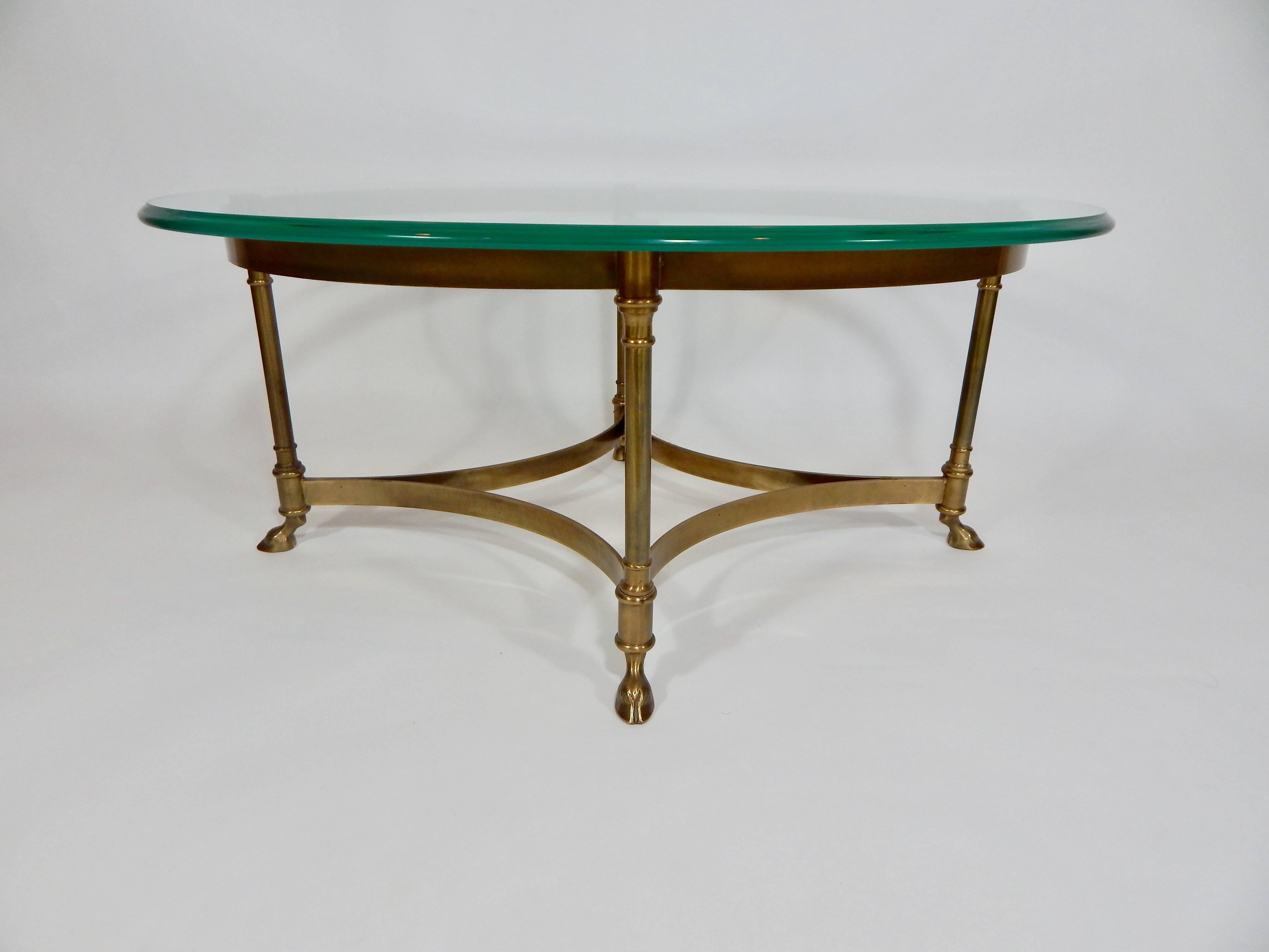 Mid-Century Weiman coffee table. Brass base with claw feet. Lightly darkened with nice Patina to brass. Removable thick and sturdy oval glass top with beveled edge. At 35 inches this is a smaller size more petite cocktail table perfect for smaller