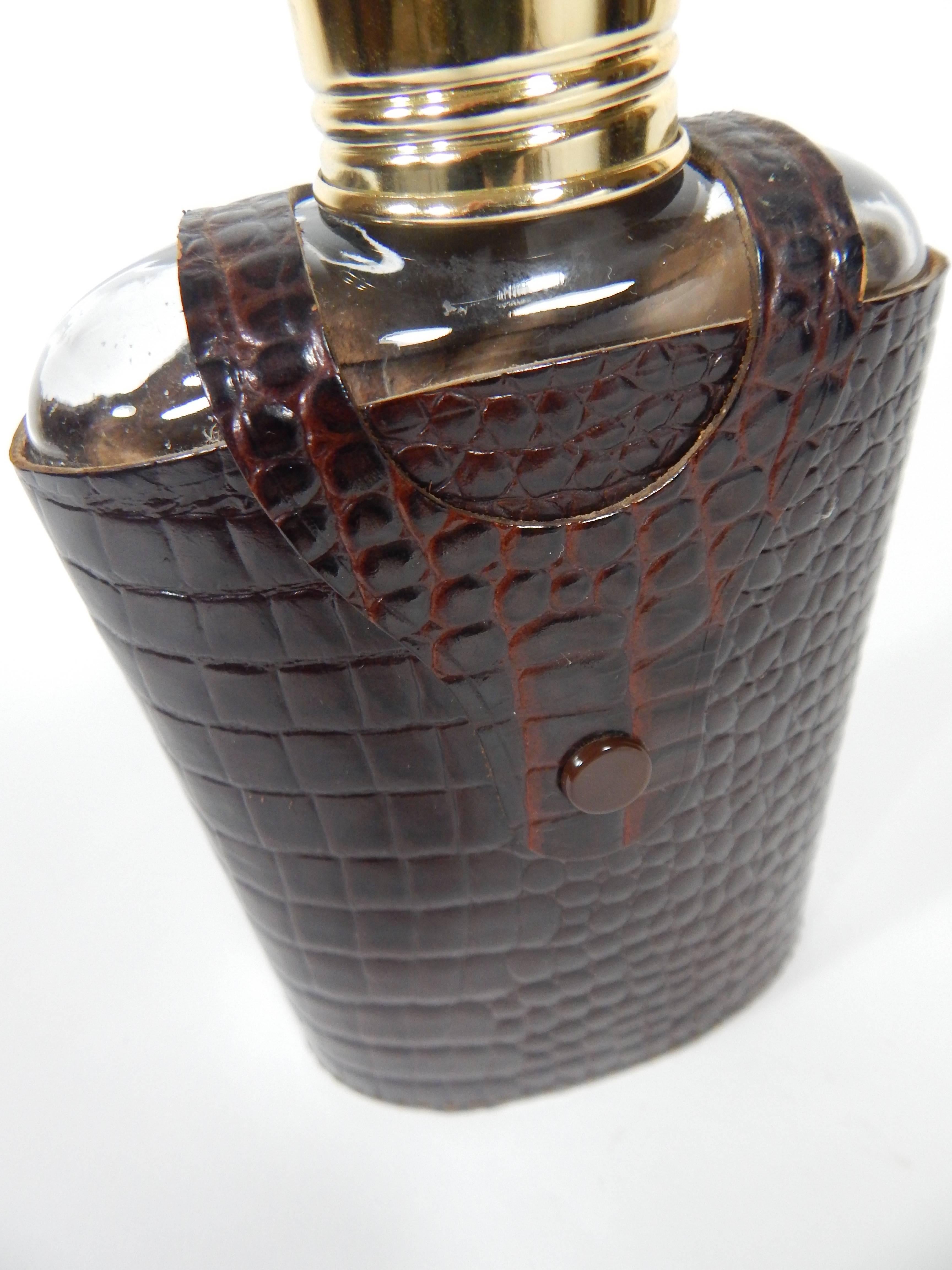 Flask in a chocolate brown Croc embossed leather with stitching. Leather case is stamped Croc Grain Hide, Made in England. The snap fastener reads Hewey England. There is a screw-on cap, and an additional screw-on lid that also works as a shot