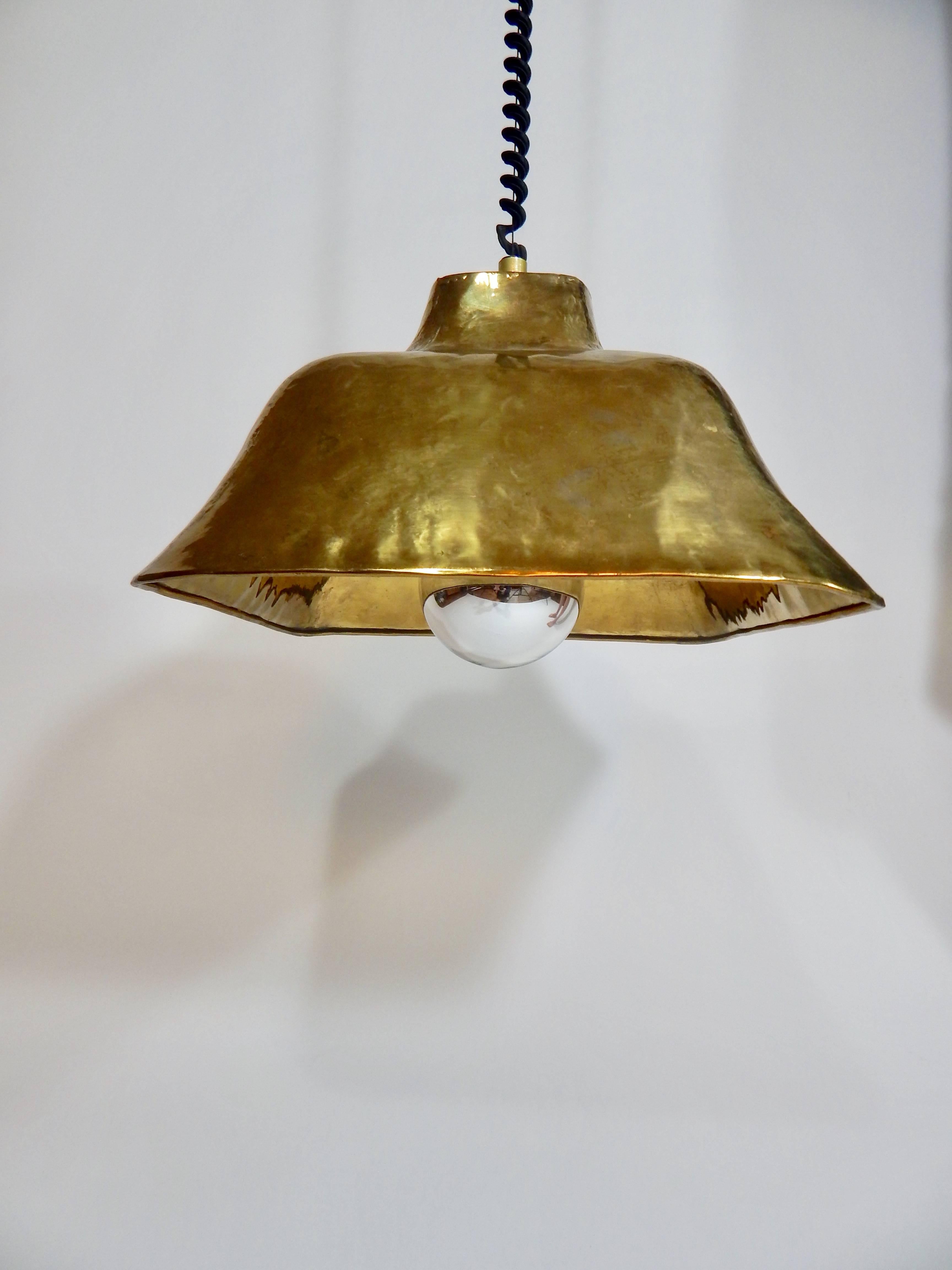 Italian midcentury hanging lamp marked Italy and dated 1974. Large globe bulb with chrome plating. Shade is brass over metal. Hanging cord is retractable and easily positioned up or down or any position in between. The retractable device was named