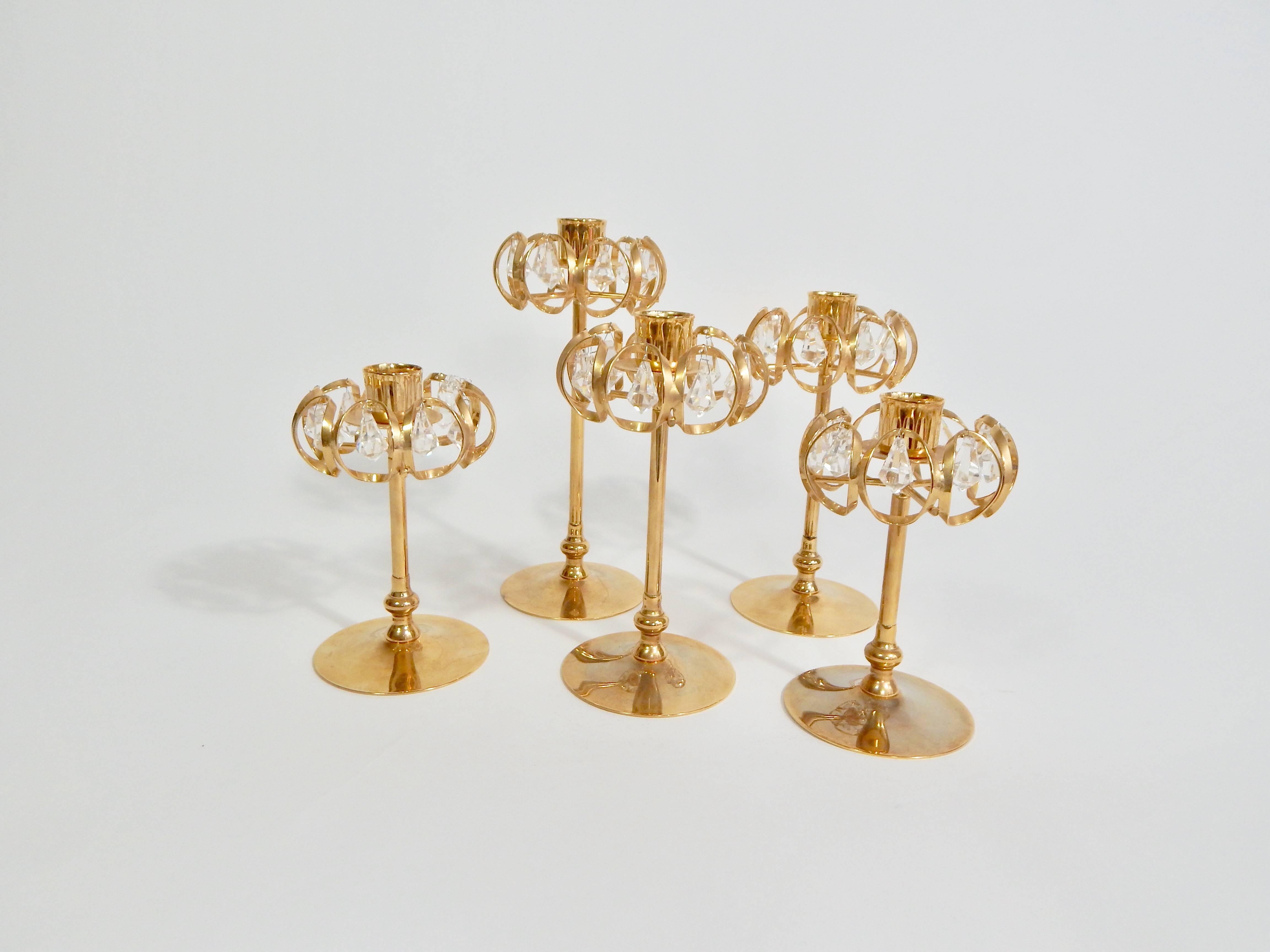 Lovely set of 24-karat gold-plated and crystal candlesticks. Made in Sweden. Marked Lycenta, 1984. Total set of five. Graduating sizes. Each has seven crystal teardrop prisms.
Measures: One height 7.5 inches
Two height 6.5 inches
Two height 5.25