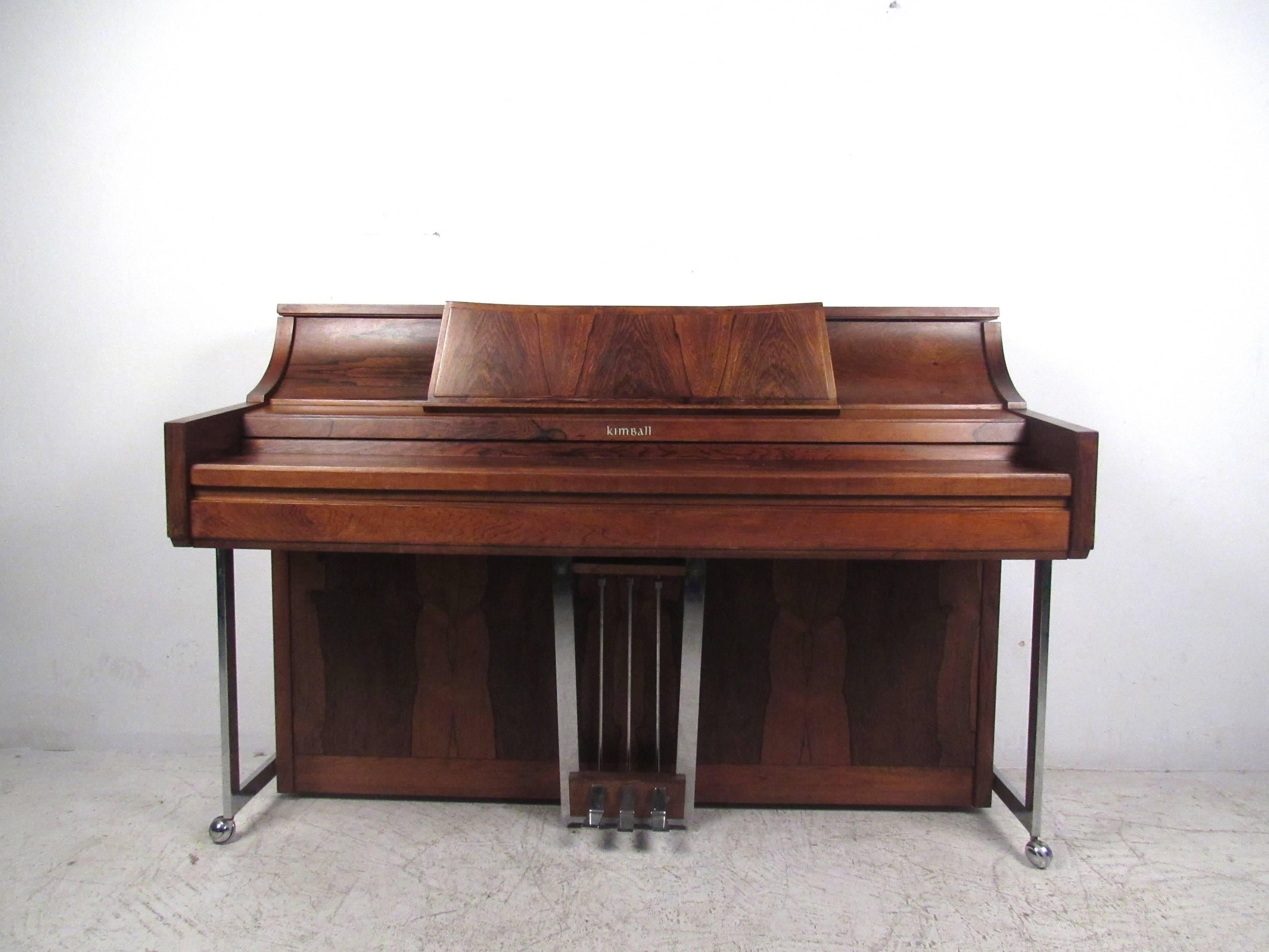 This beautiful rosewood and chrome style features the mid-century design style of the great Milo Baughman and makes a stylish musical addition to any interior. Paired with matching piano bench with added storage, this beautiful yet compact piano is